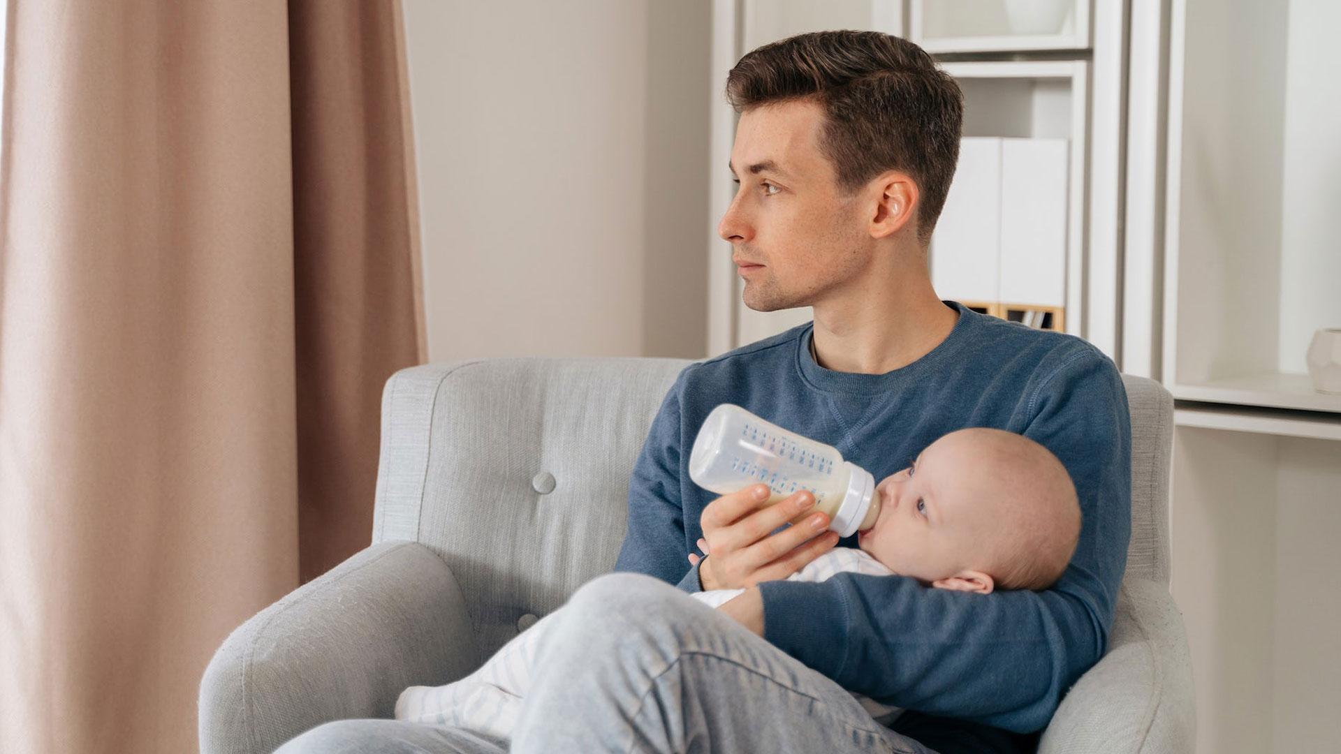 Un padre da el biberón a un bebé