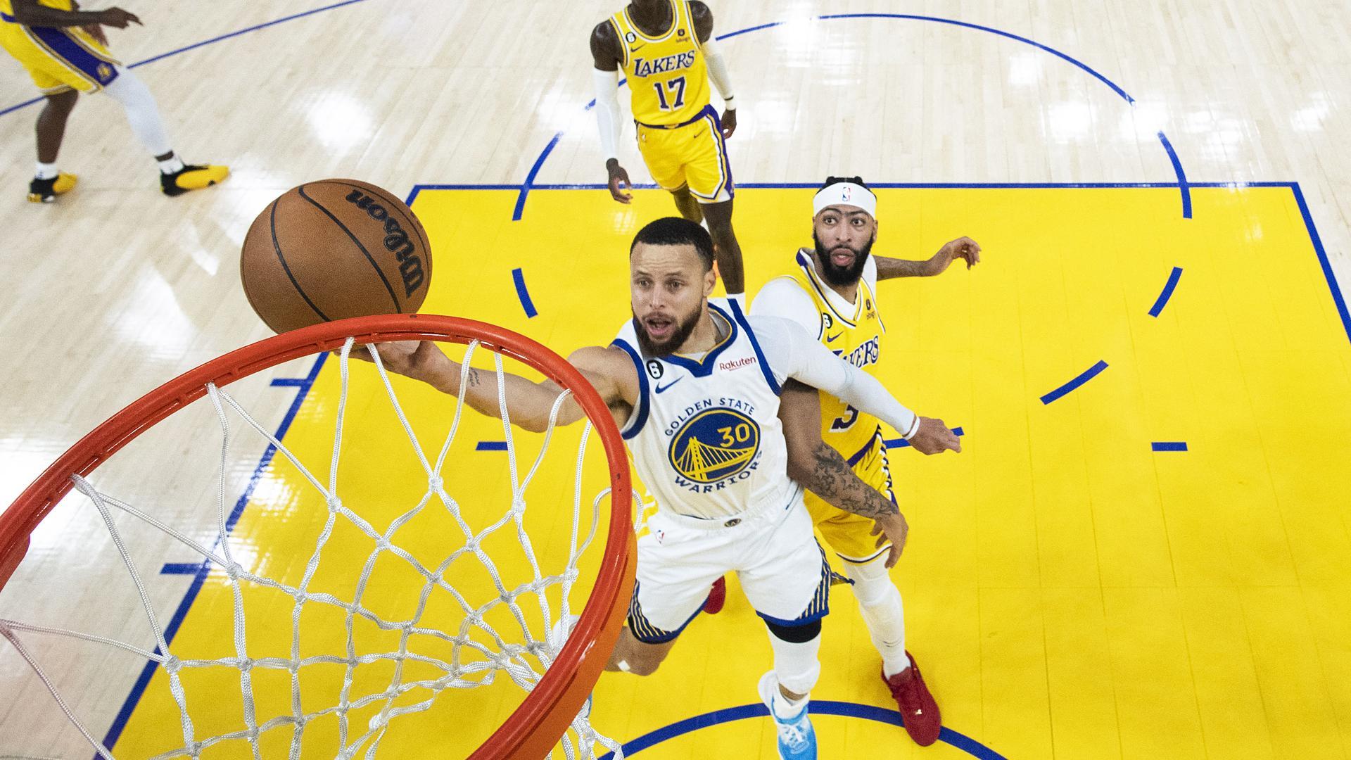 Stephen Curry entra a canasta tras sortear a Anthony Davis durante el encuentro