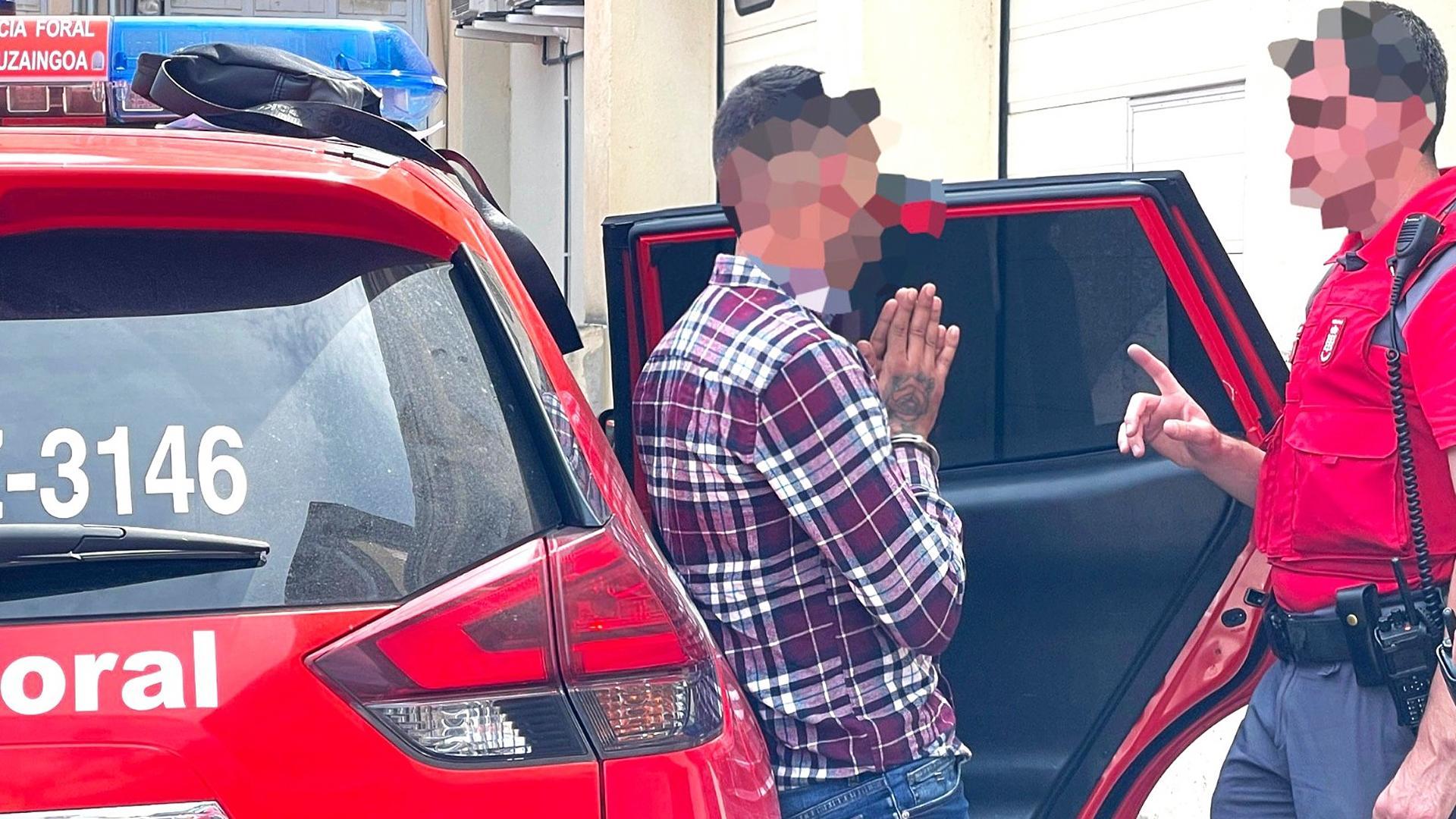 Un agente de la Policía Foral habla con una persona detenida por malos tratos en Pamplona