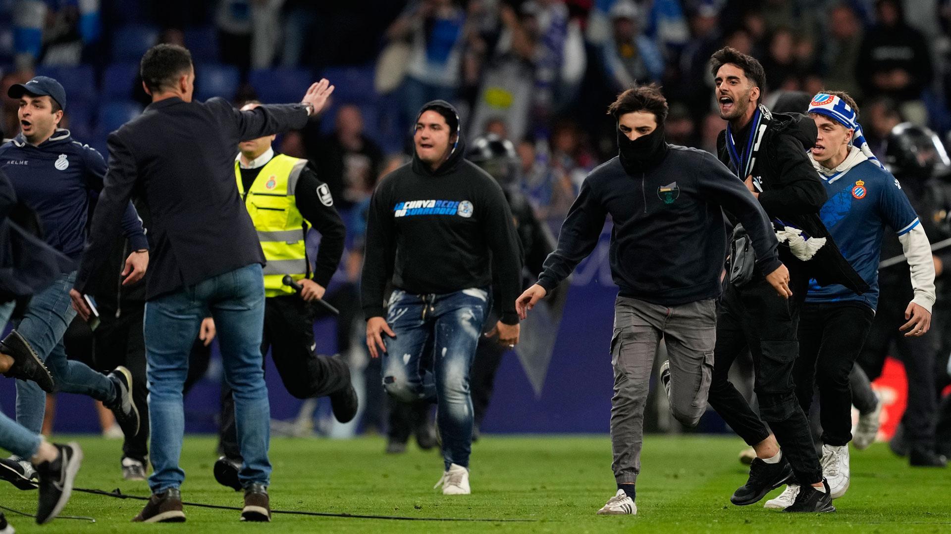 Cientos de aficionados invaden el campo al término del partido que el RCD Espanyol y el FC Barcelona