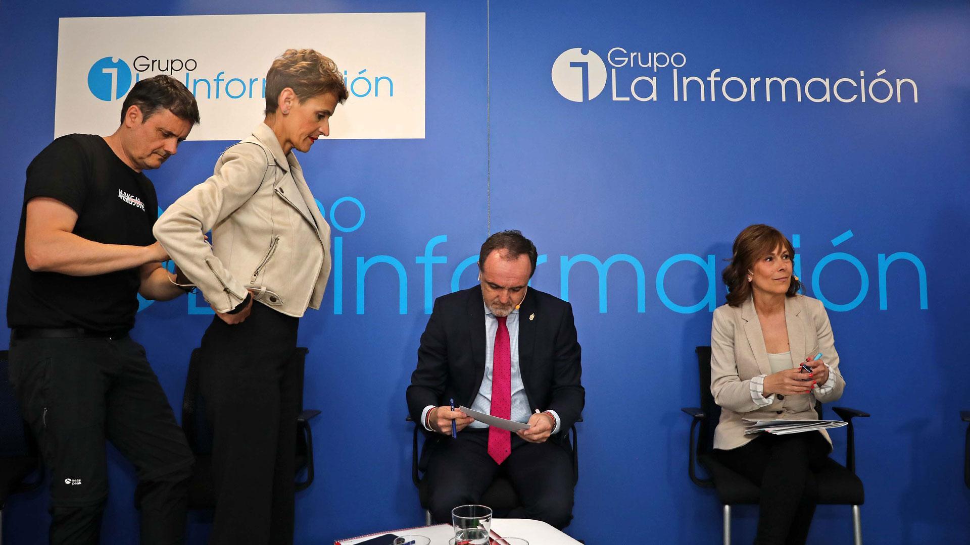 Un técnico coloca la petaca del micro a María Chivite, con Javier Esparza y Uxue Barkos en sus sillas