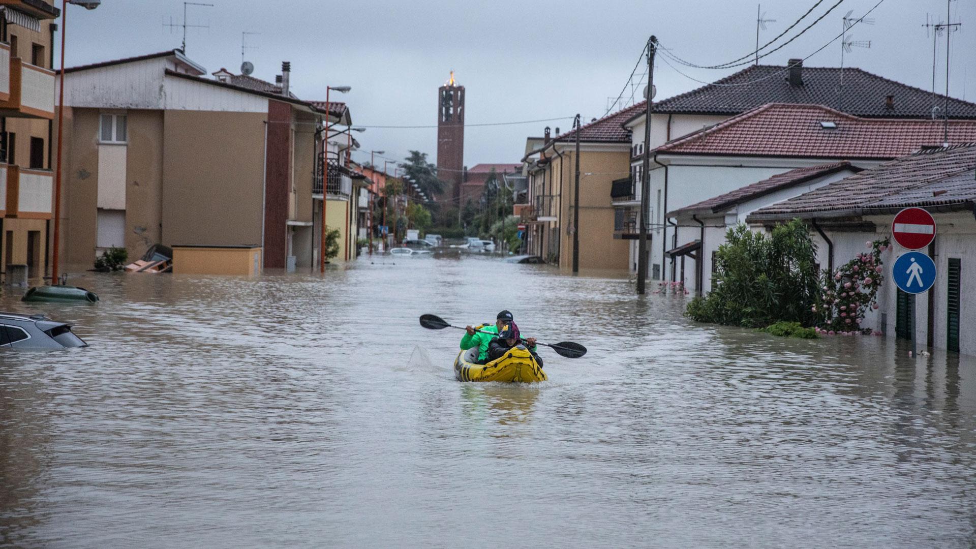 Una persona navega con un kayak inflable por una calle inundada en Cesena, tras una lluvia torrencial que azota la región de Emilia-Romaña en Italia