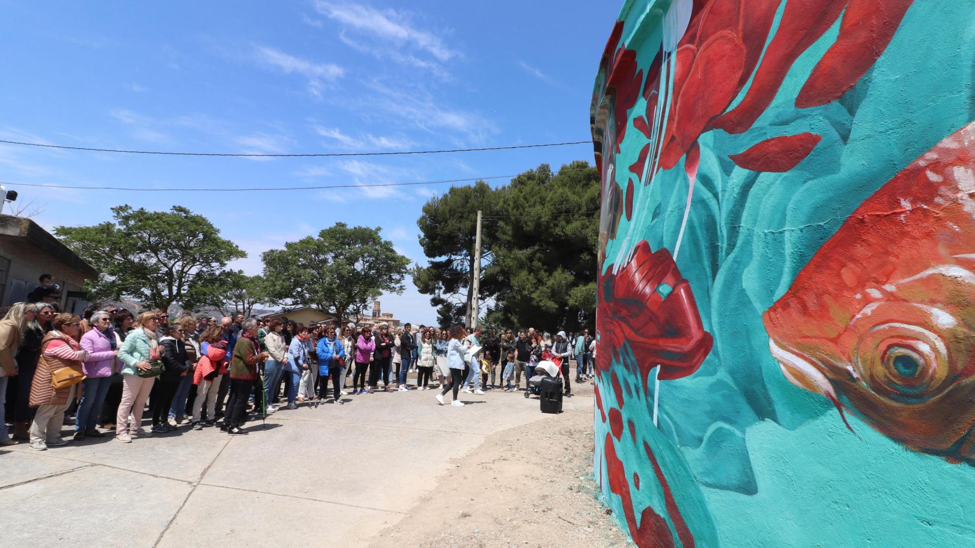 Asistentes a las visitas guiadas a las obras de la tercera edición del festival contemplan uno de los murales.