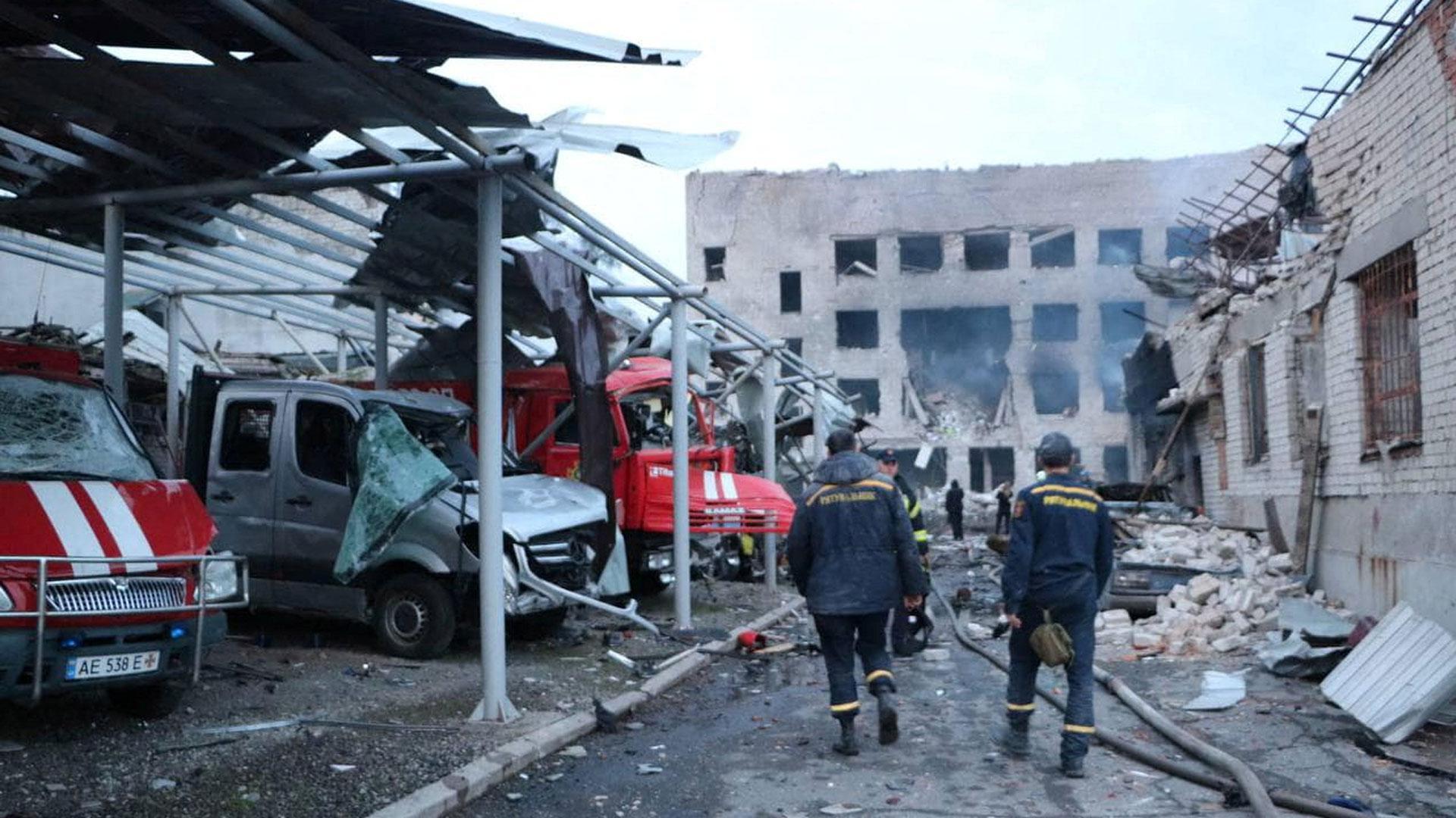 Personal de rescate camina junto a los vehículos destruidos en un complejo de bomberos del Servicio Estatal de Emergencia gravemente dañado por un ataque con misiles rusos, en Dnipro