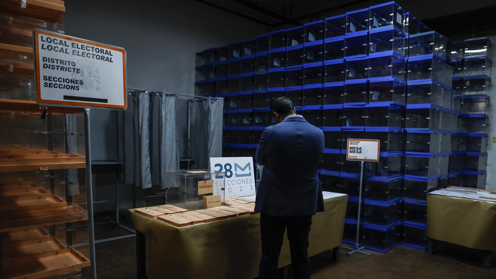 Una persona, junto a papeletas electorales para las próximas elecciones municipales del 28 de mayo
