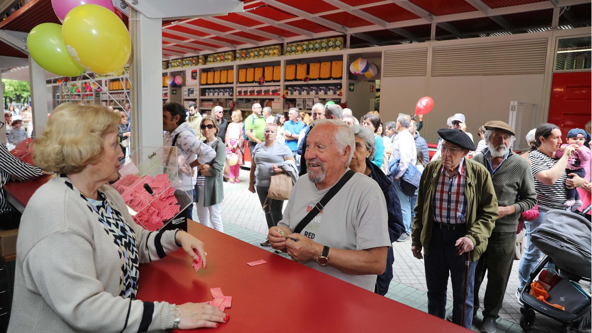 Una voluntaria de Cáritas vendiendo los primeros boletos tras la inauguración ayer de la tómbola.