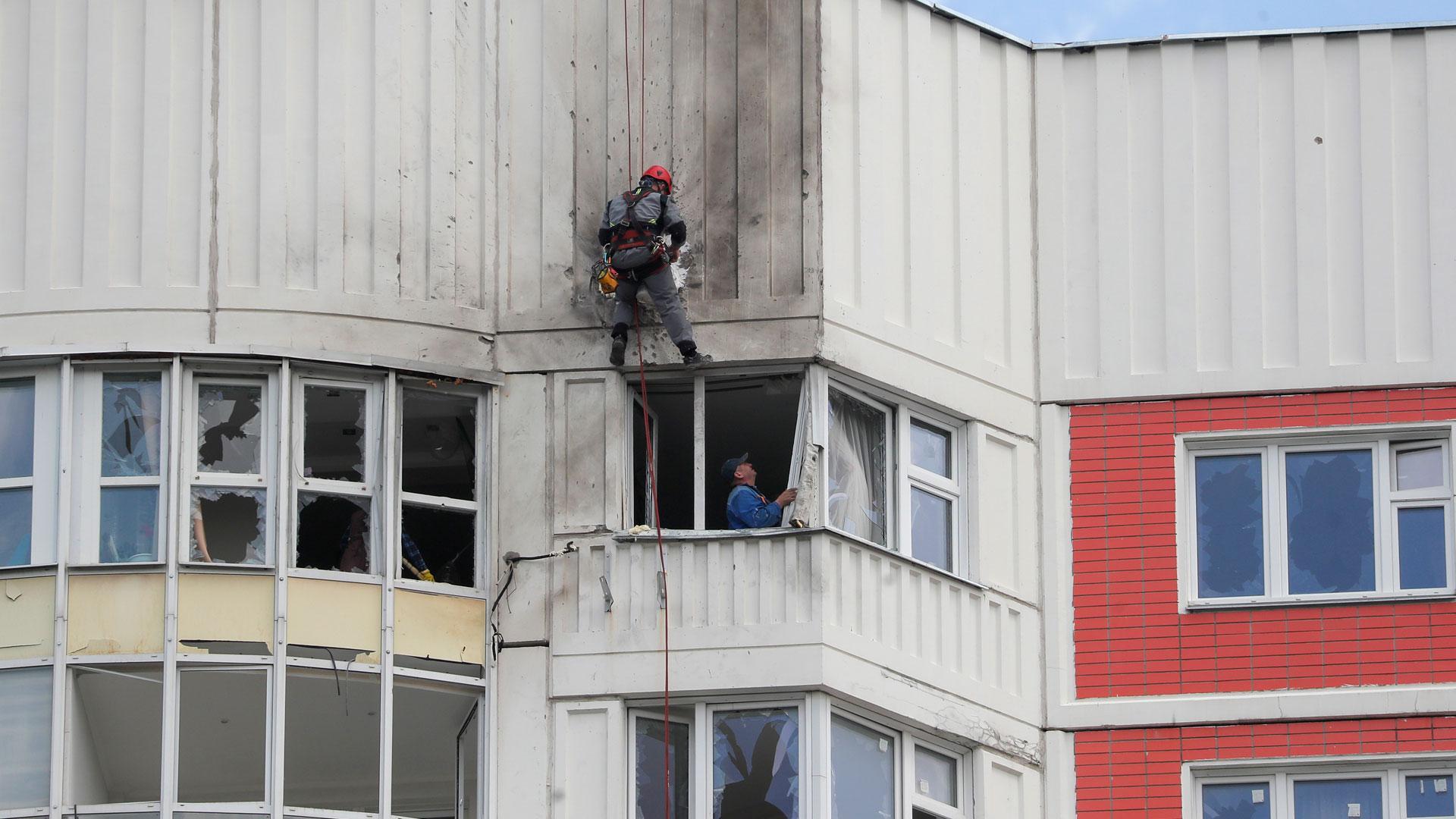 Trabajadores reparan un edificio residencial dañado tras el primer ataque con drones sufrido por Moscú