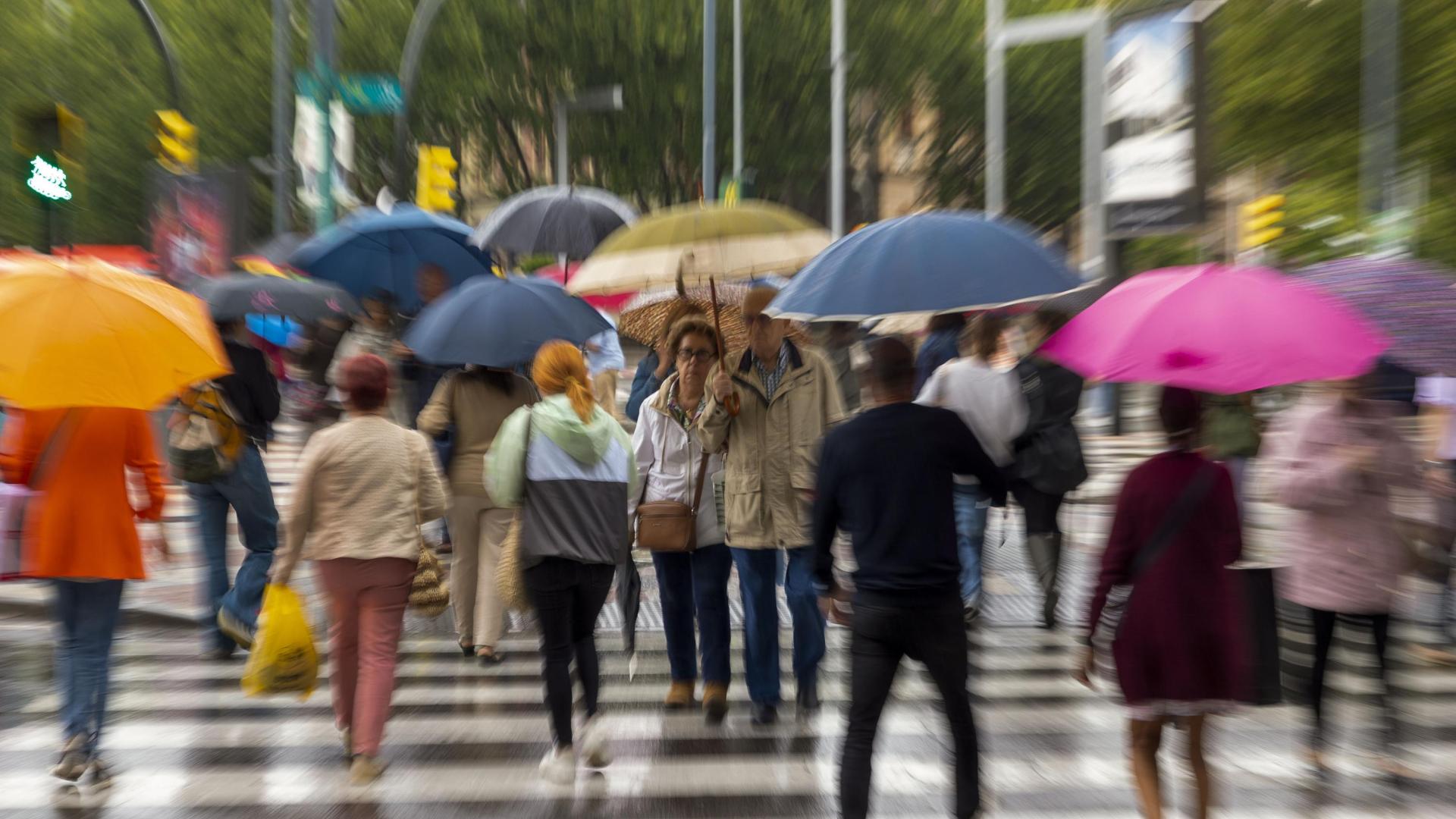 Varias personas se protegen de la lluvia caída este jueves en Zaragoza