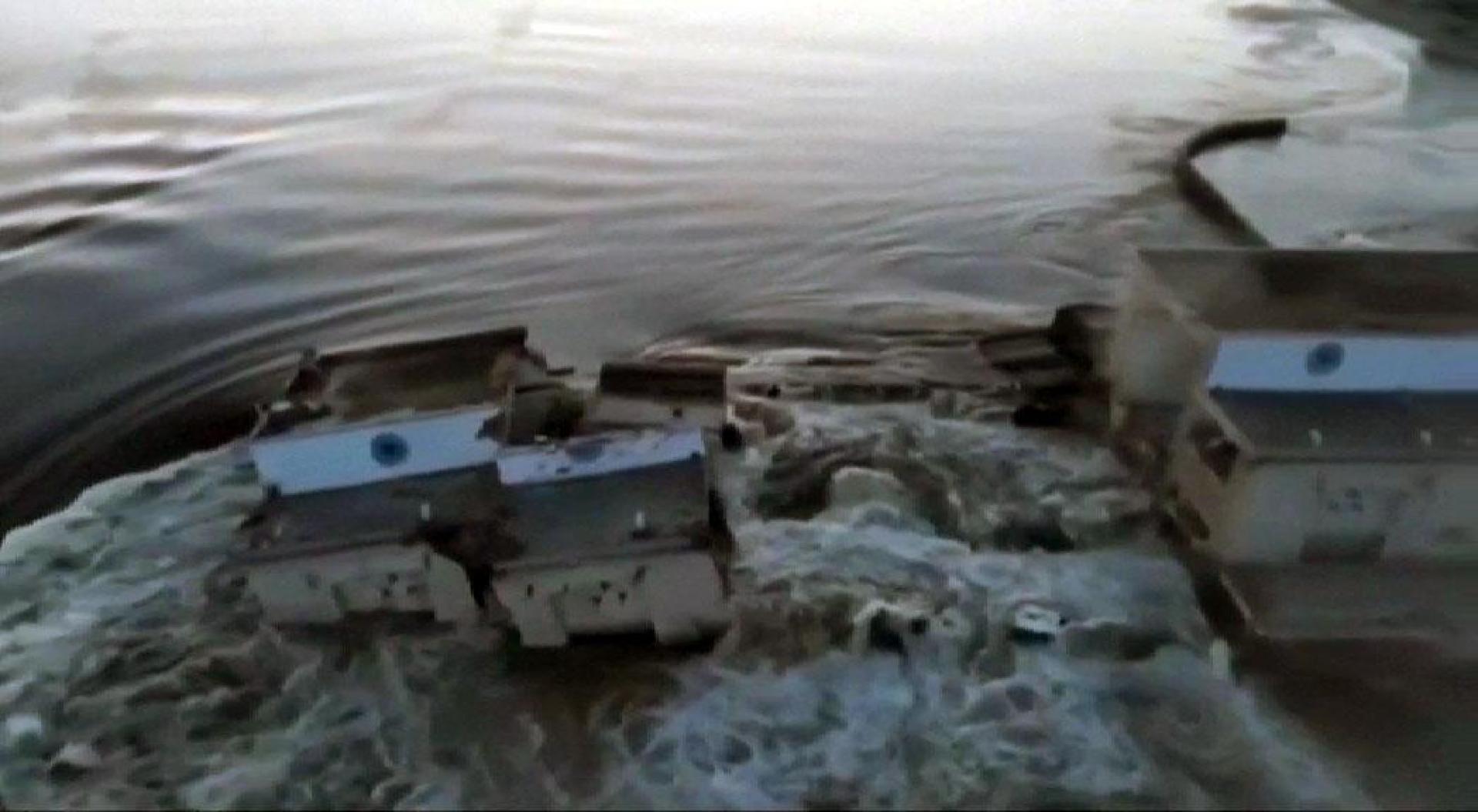 Máxima preocupación en Ucrania por el ataque a la presa del río Dniepper. El ejército ucraniano culpa a las tropas rusas y estos aseguran que ha sido un sabotaje. La explosión de la presa de Nova Katkova ha provocado un gran boquete en el muro de contención que hace que agua fluya descontrolada hacia las poblaciones cercanas, arrasando todo tipo de construcciones como este puente. El riesgo para los habitantes es máximo. 80 pueblos pueden quedar inundados. Además, esta presa es la que alimenta la central nuclear de Zaporiya y enfría sus reactores.