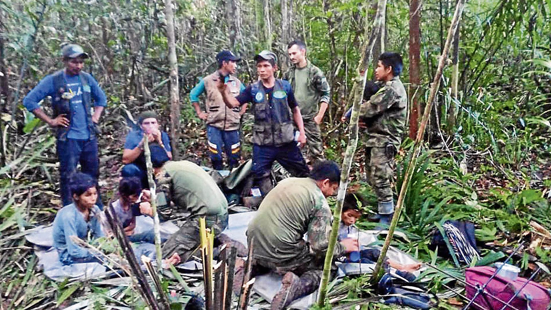 Fotografía cedida por las Fuerzas Militares de Colombia que muestra a soldados e indígenas atendiendo a los niños rescatados tras 40 días en la selva, en Guaviare
