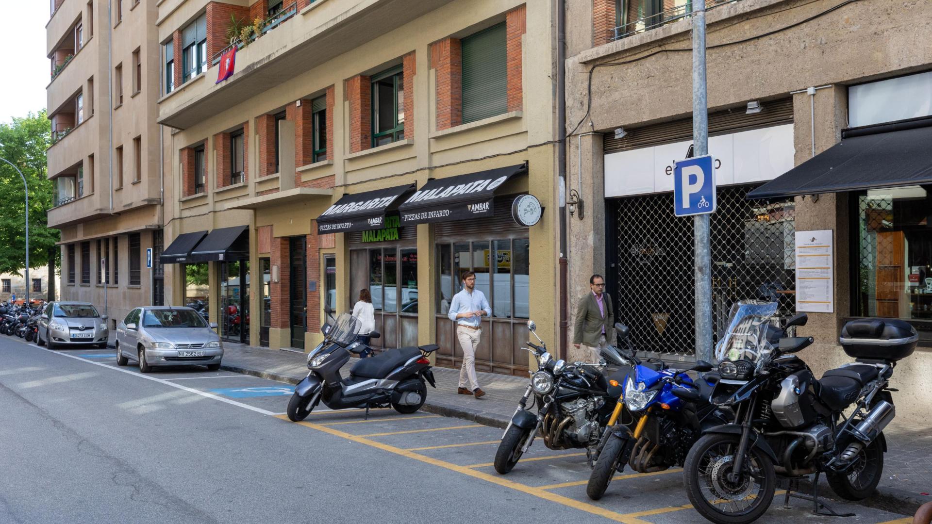 Plazas de motos y de movilidad reducida junto a tres establecimientos de hostelería de la calle García Castañón