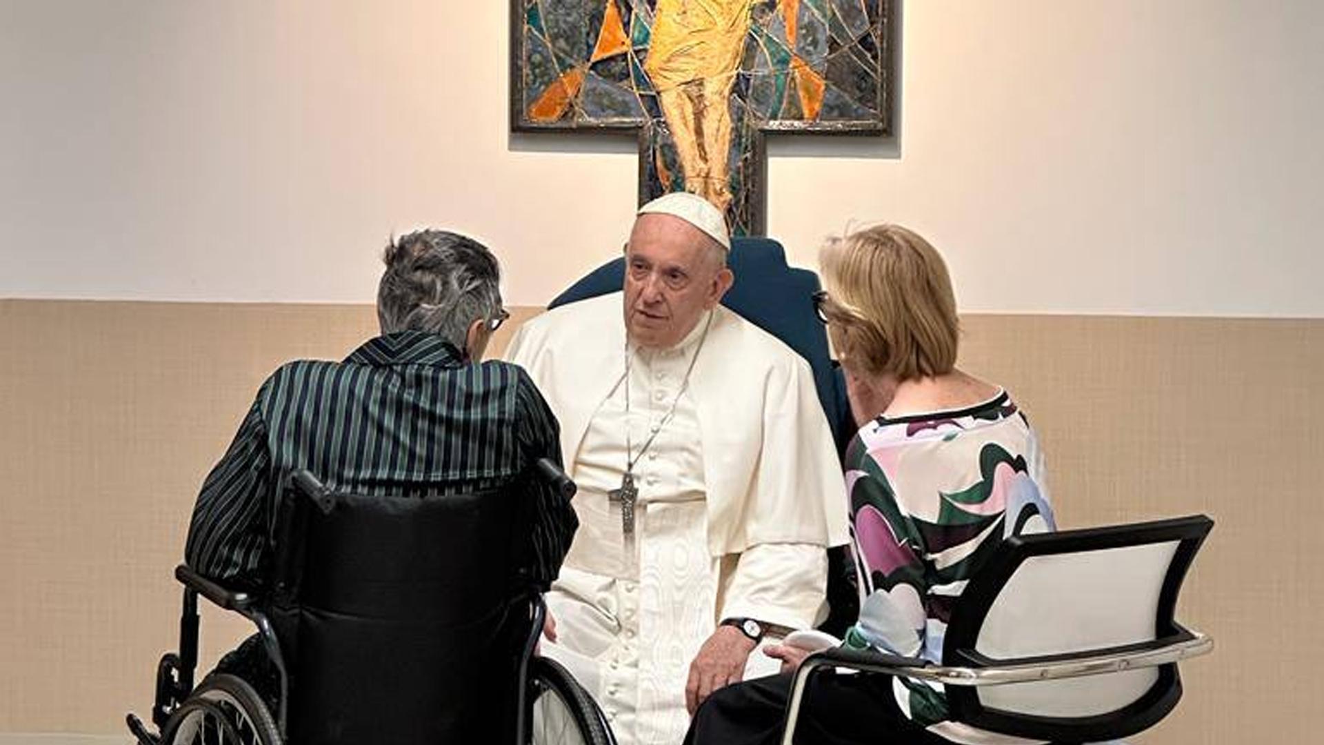 El papa Francisco conversa con un paciente y una acompañante mientras visita este jueves el departamento de oncología y neurocirugia pedriática del hospital Gemelli de Roma