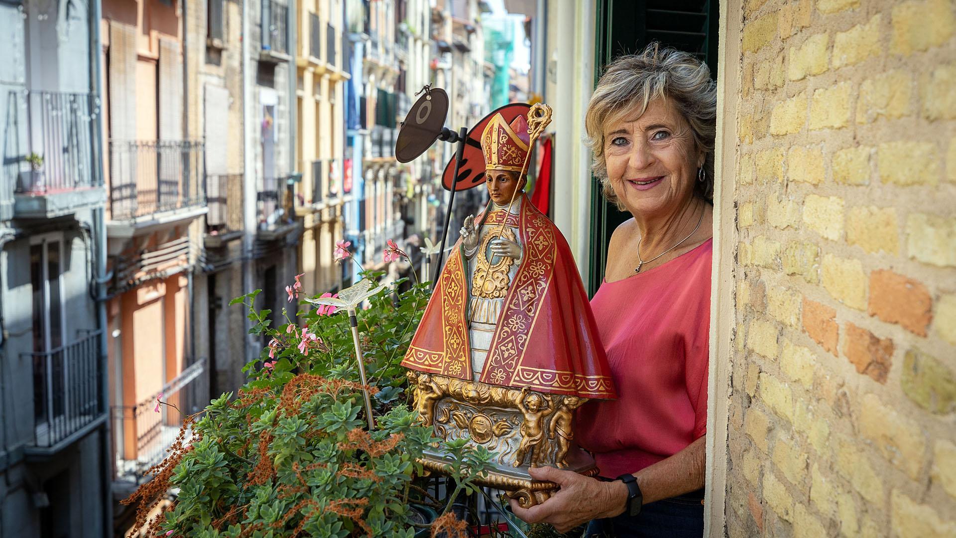 Mariví Esparza Mugueta, asomada a un balcón de su casa, con el San Fermín que cada mañana preside el encierro
