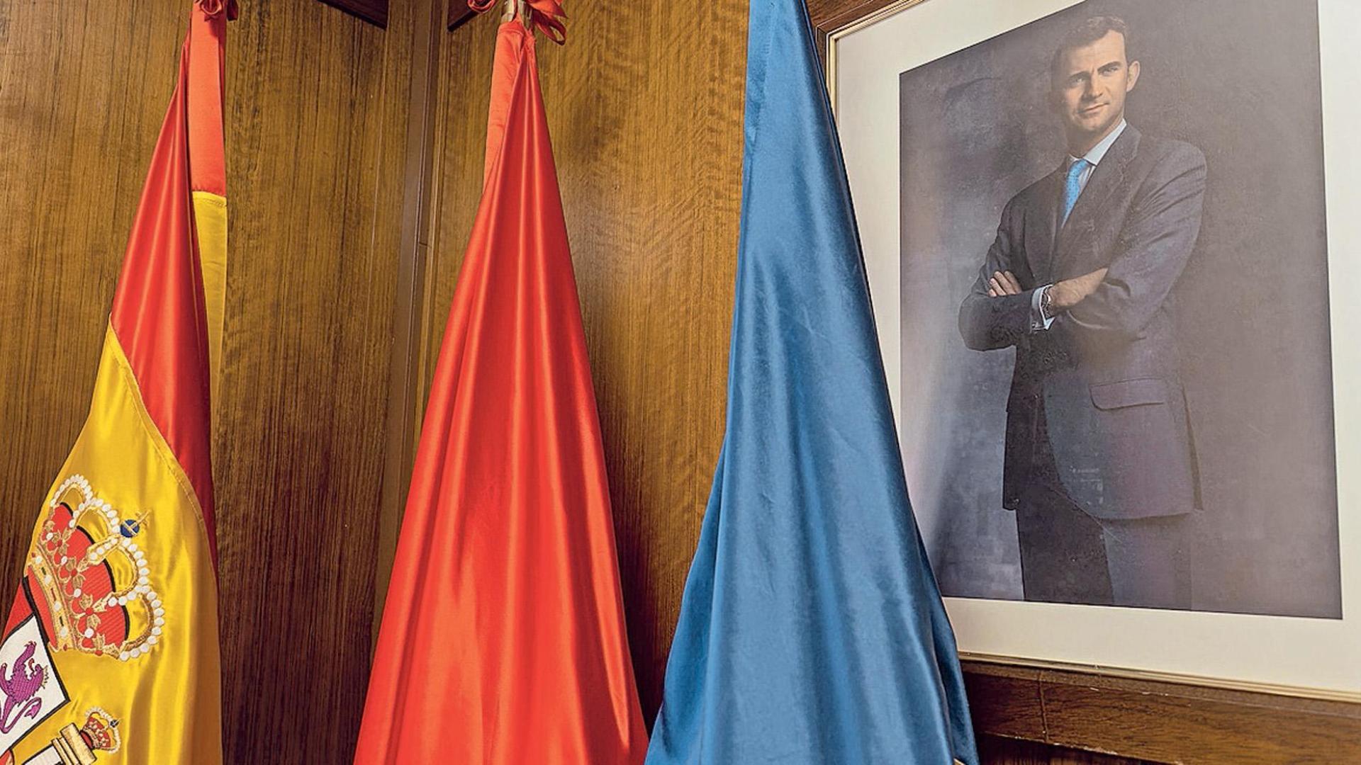 Rincón del salón de plenos de Estella, con las banderas y el retrato del rey