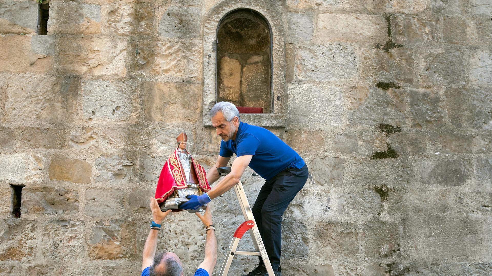 Momento en el que operarios municipales retiran la imagen de San Fermín de la hornacina de la cuesta de Santo Domingo