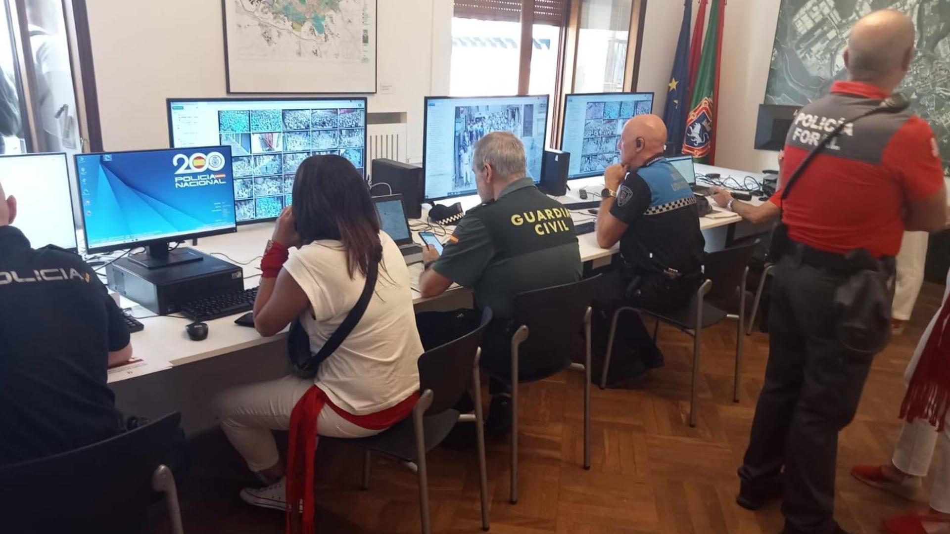Representantes de todos los cuerpos policiales siguen las imágenes de las cámaras, ayer en el Ayuntamiento pamplonés