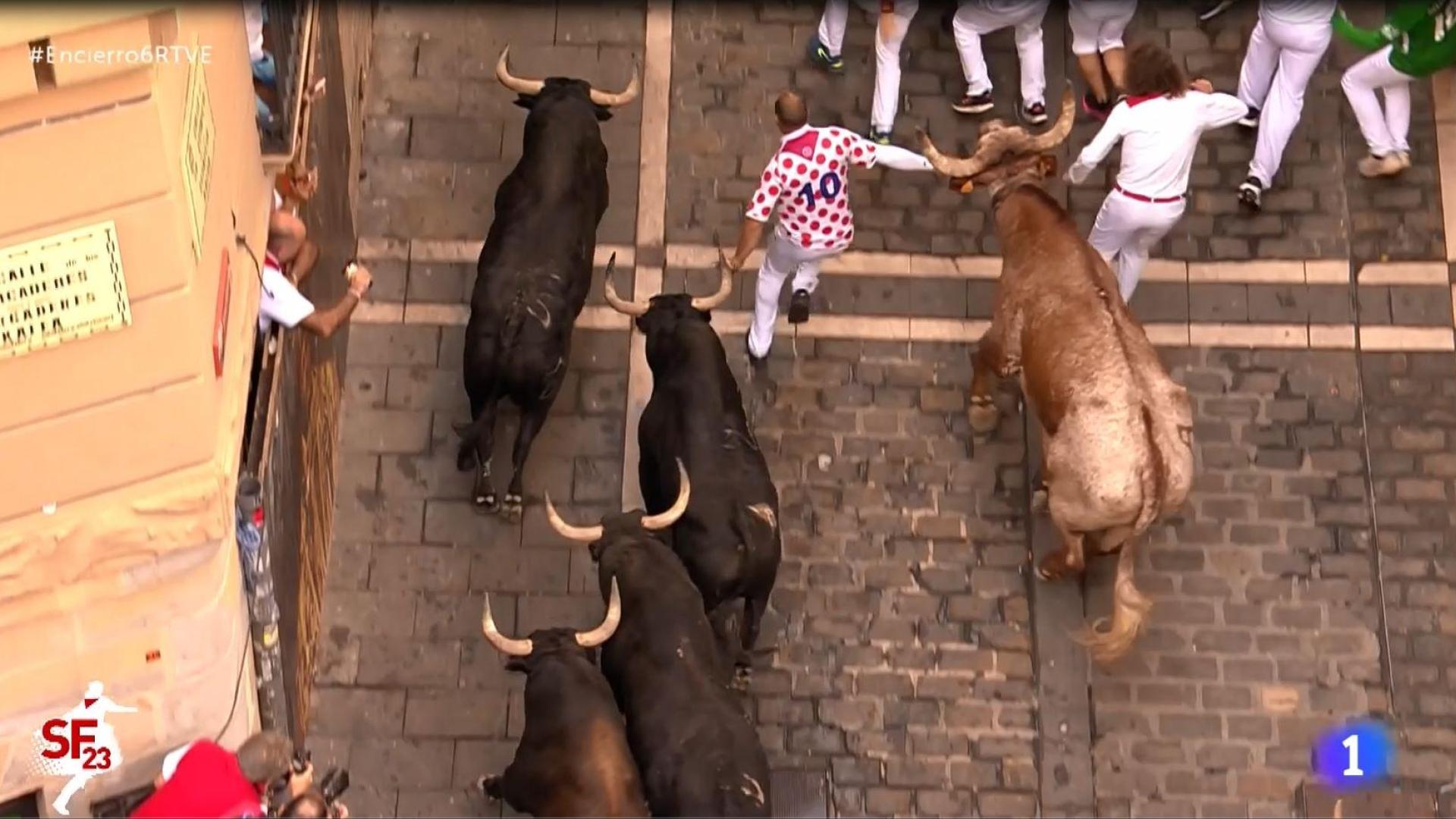 Un manso empuja a un mozo y lo coloca entre dos toros en Estafeta
