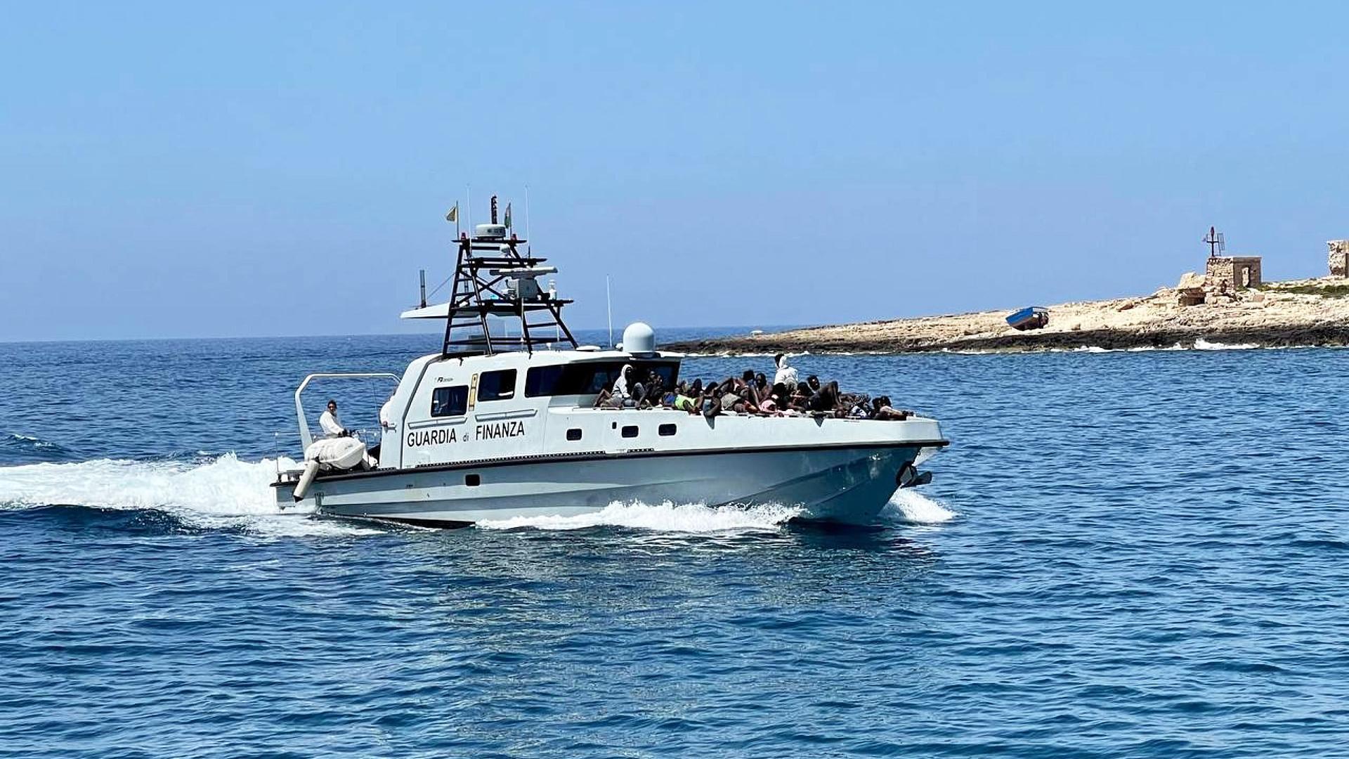 Una patrulla de guardacostas italiano transporta a varios inmigrantes rescatados en las proximidades del puerto de Lampedusa