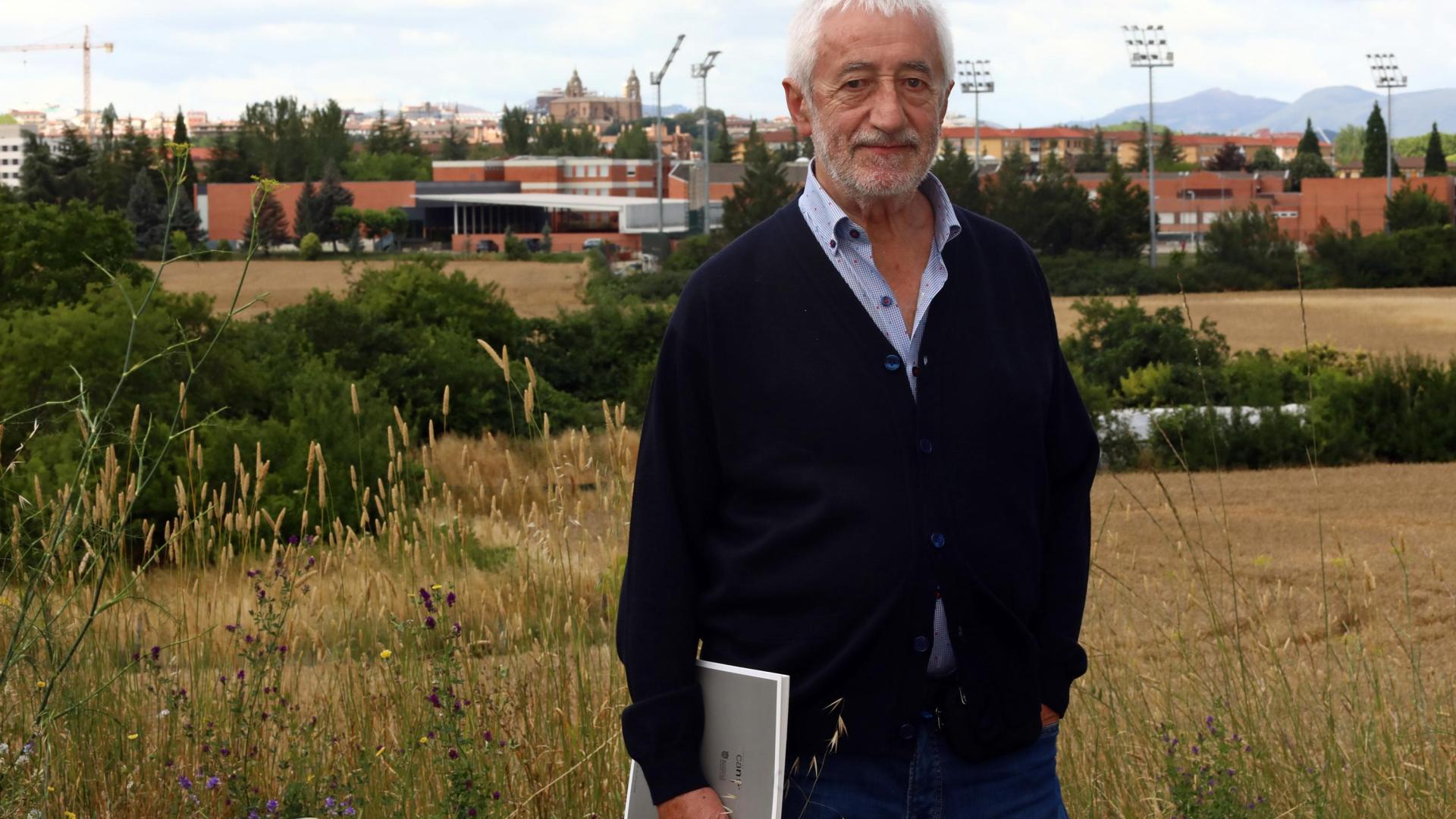 El pintor Pedro Salaberri posa en su lugar escogido para la serie junto con un libro que recoge varias de sus obras