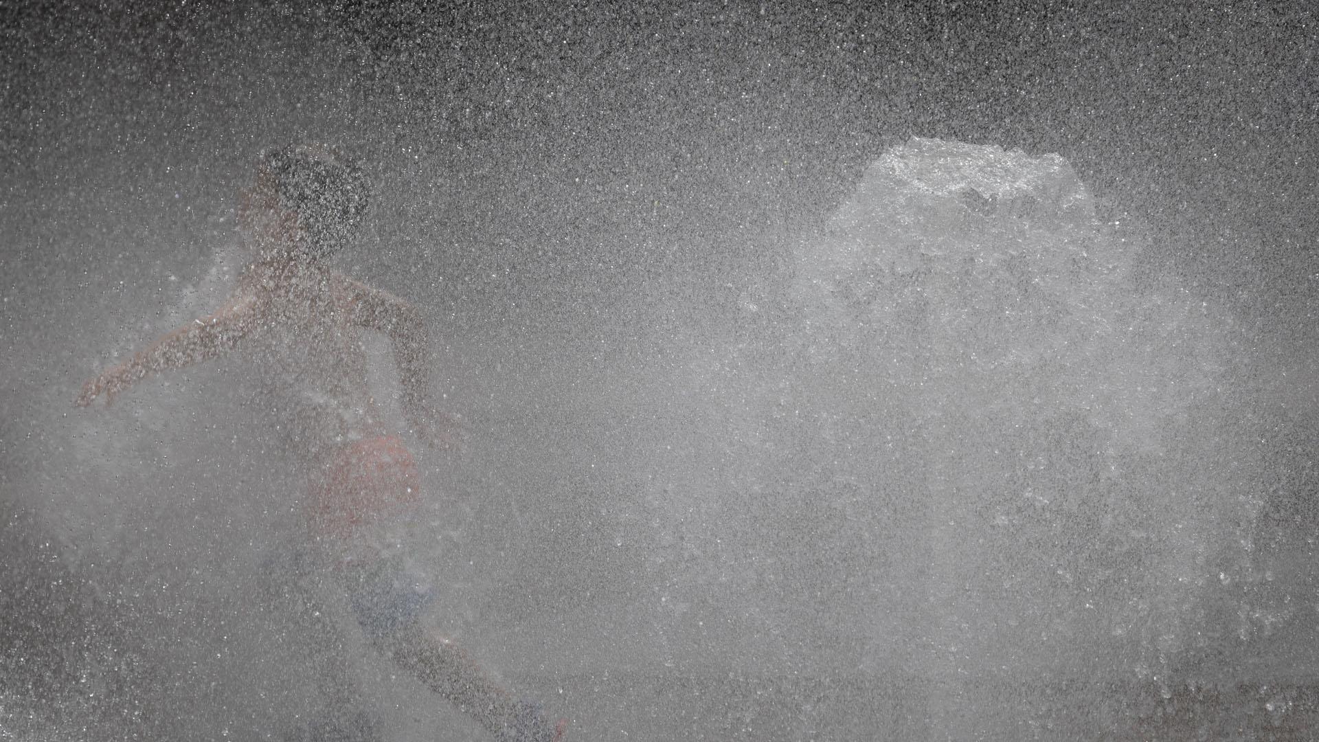 Varios niños se refrescan en una fuente en Pamplona