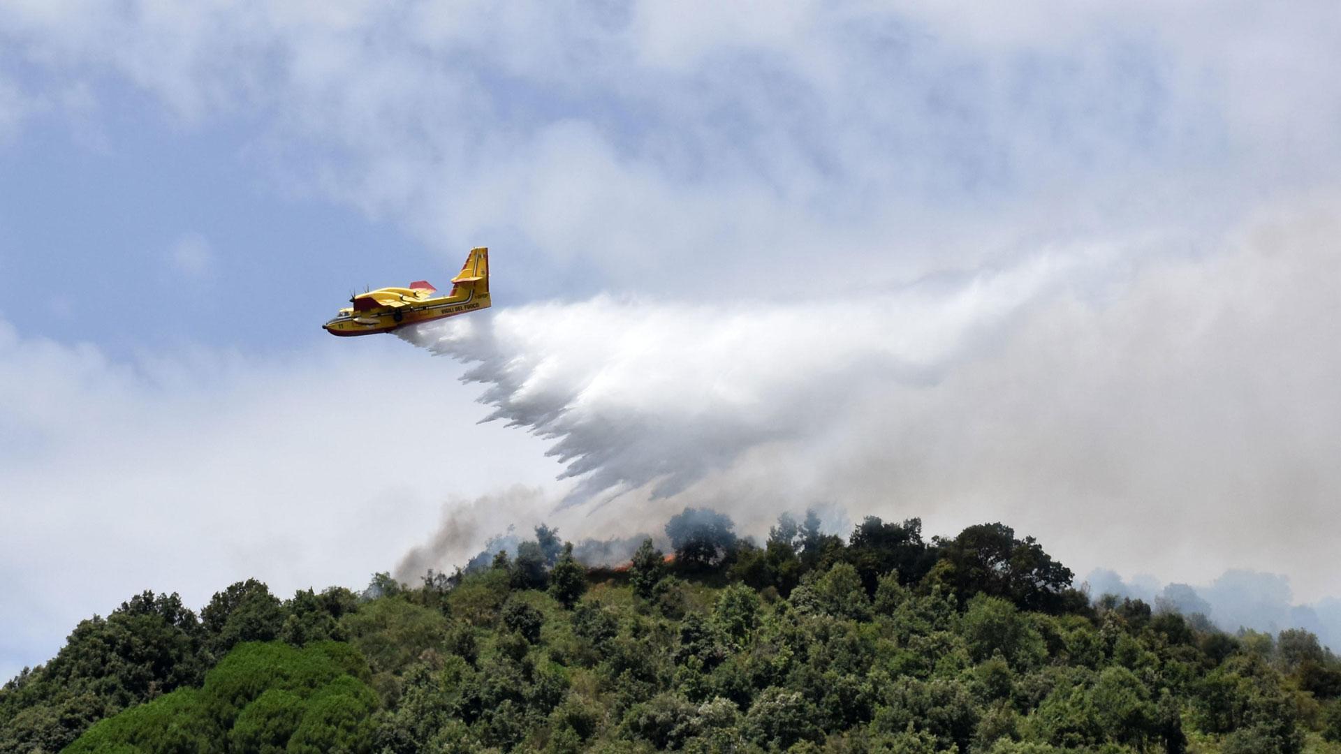 Imagen de un helicóptero echando agua sobre un incendio en la isla de Sicilia