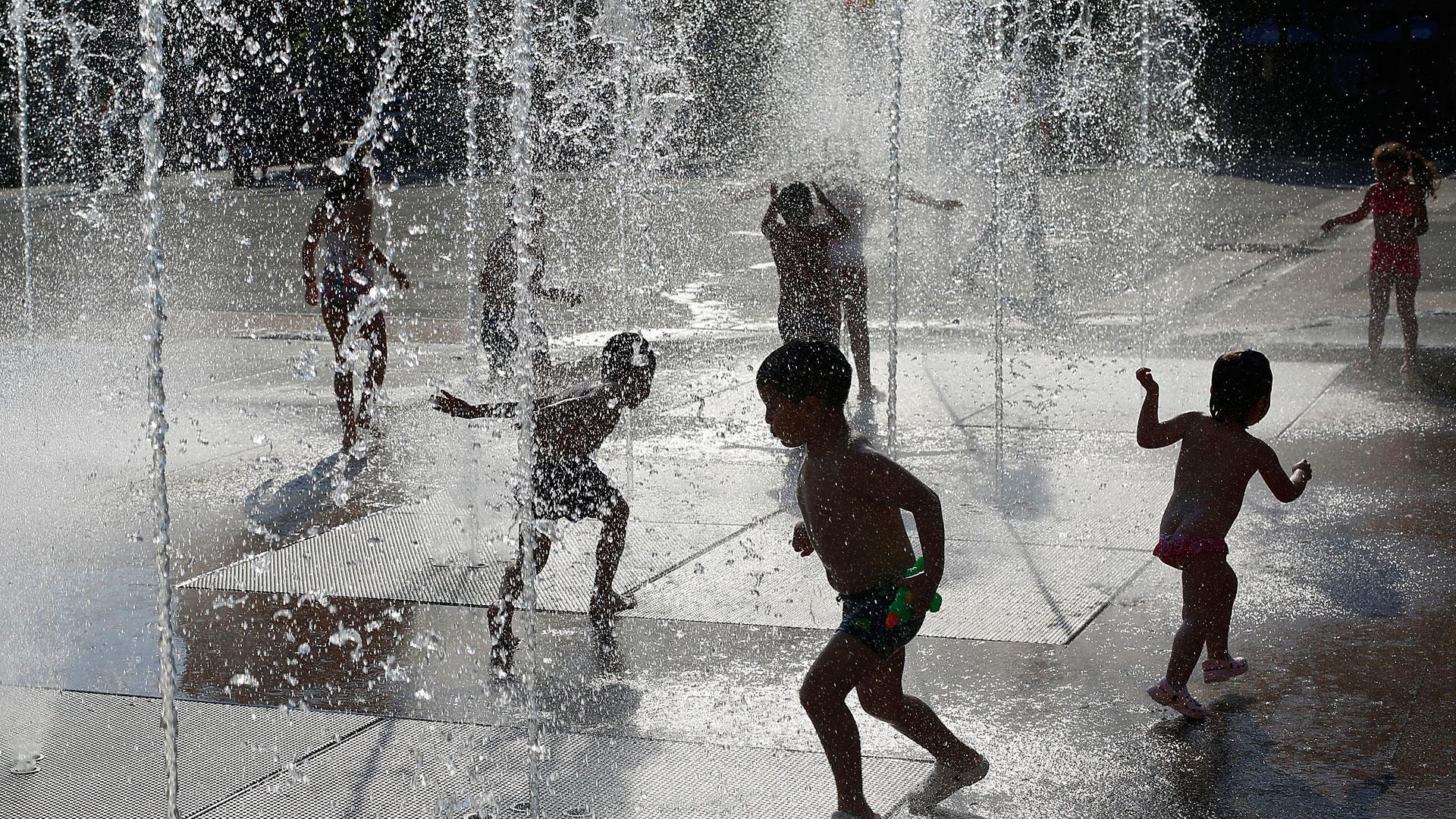 Una imagen refrescante de niños bajo unos chorros de agua en la plaza Yamaguchi