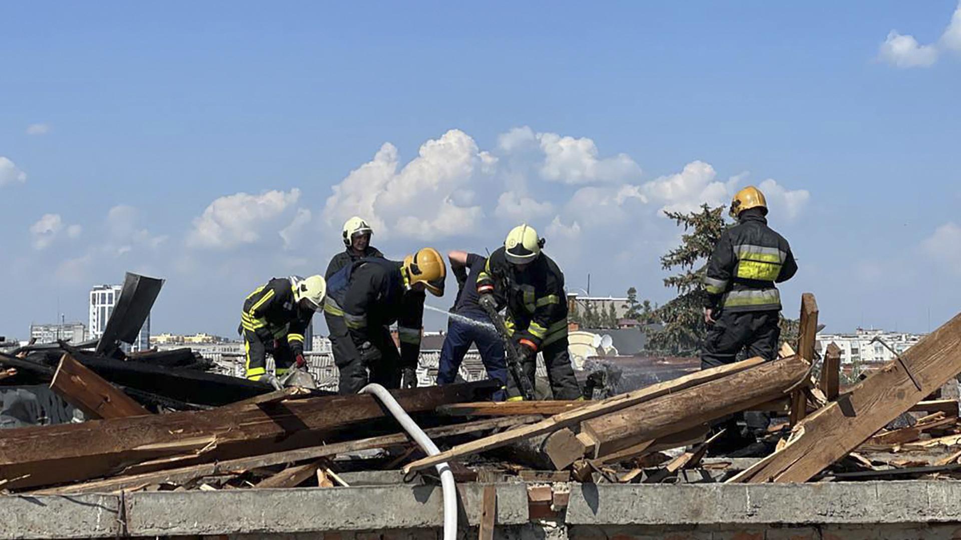 Una foto facilitada por el Servicio Estatal de Emergencias de Ucrania muestra a los equipos de rescate trabajando en la zona donde cayó un misil en el Teatro Dramático del centro de Cernihiv, Ucrania
