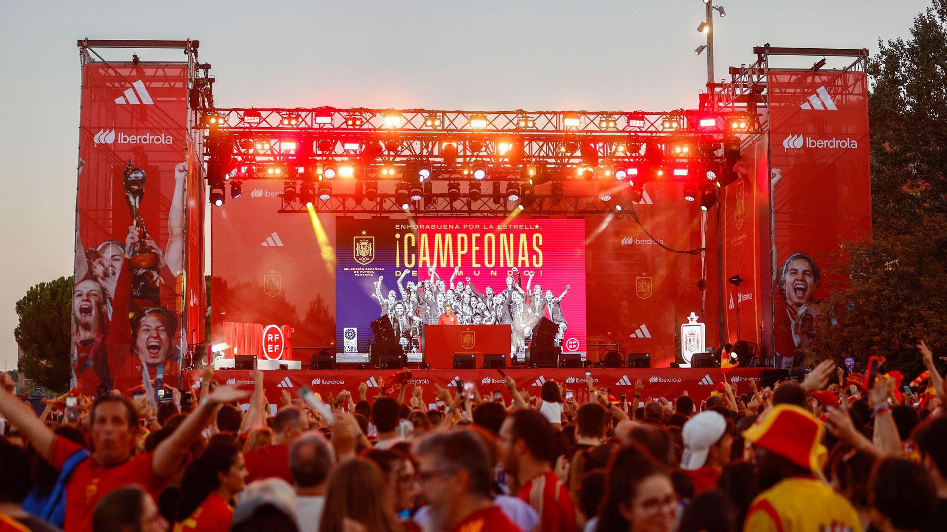 Miles de personas asisten a la fiesta de recibimiento a la selección femenina de fútbol mientras esperan a que el autobús que traslada a las campeonas del mundo llegue a la explanada de Puente del Rey