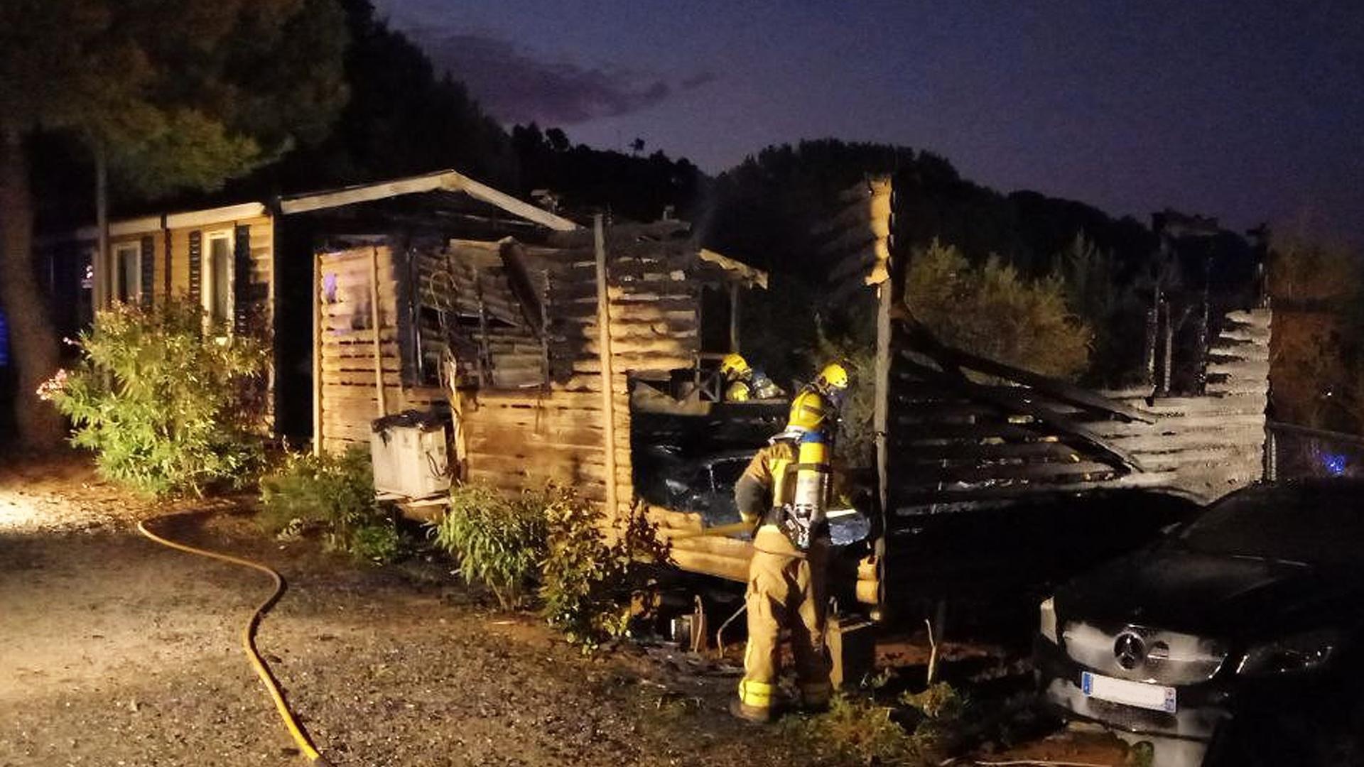 Efectivos de Bomberos de Cataluña trabajan en la extinción del fuego en el bungalow afectado