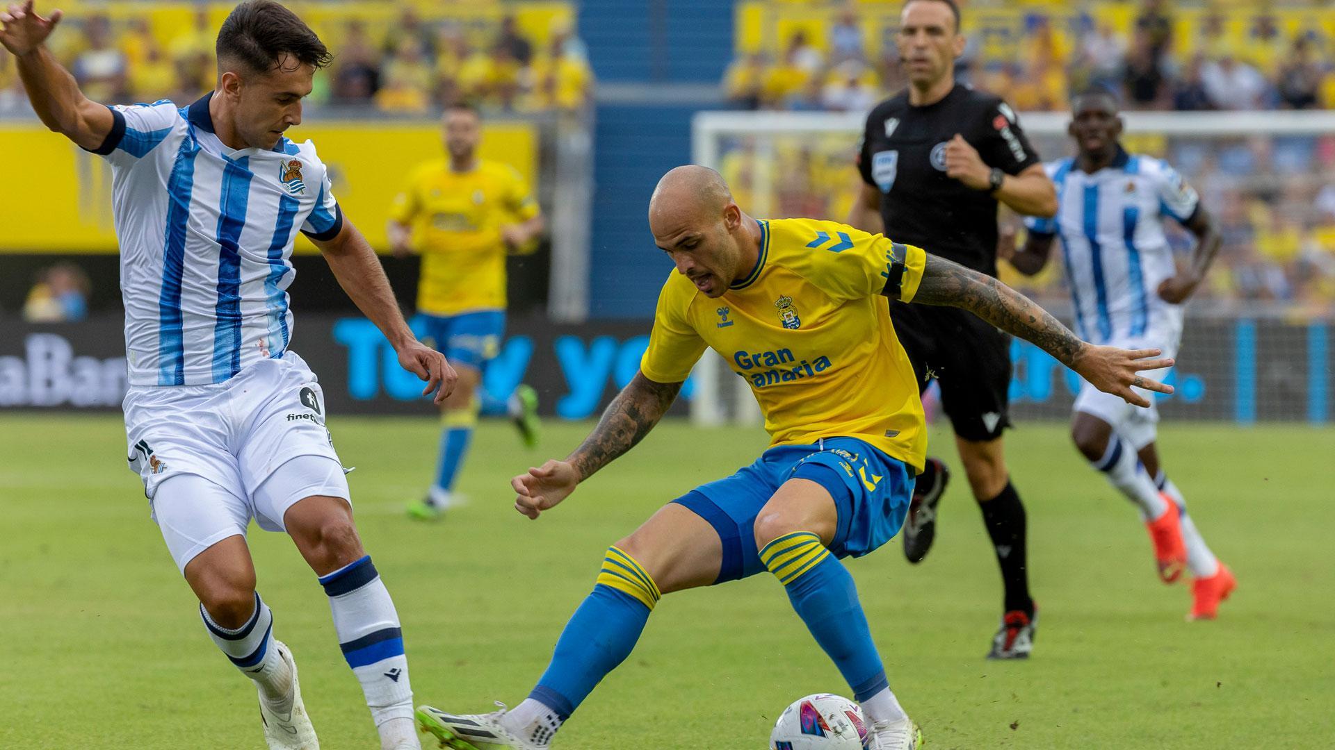 El delantero de la UD Las Palmas Sandro Ramírez lucha con Martín Zubimendi, de la Real Sociedad, durante el partido de la tercera jornada de Liga