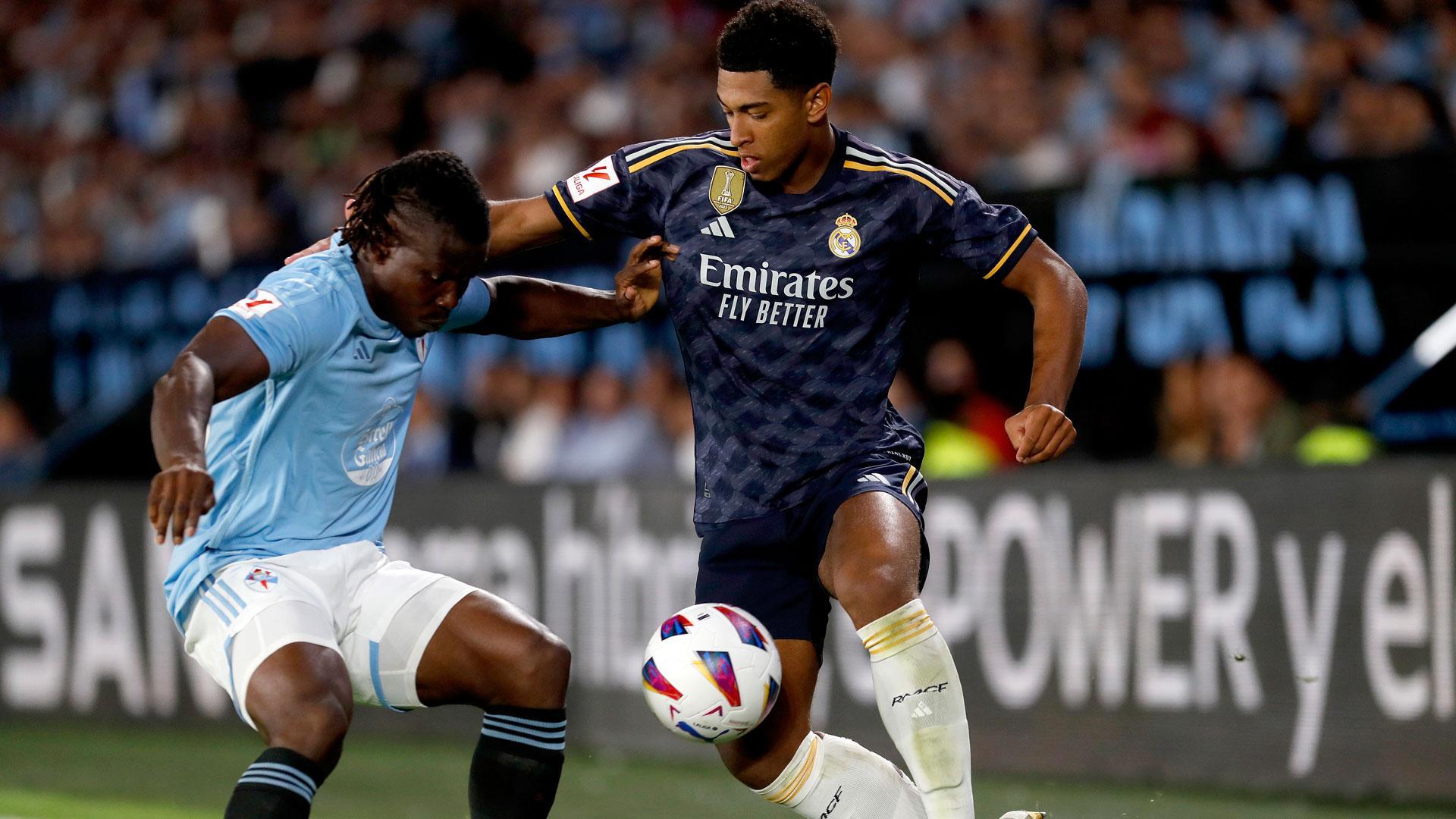El centrocampista británico del Real Madrid Jude Bellingham (d) lucha con el ghanés Joseph Aidoo, del Celta de Vigo