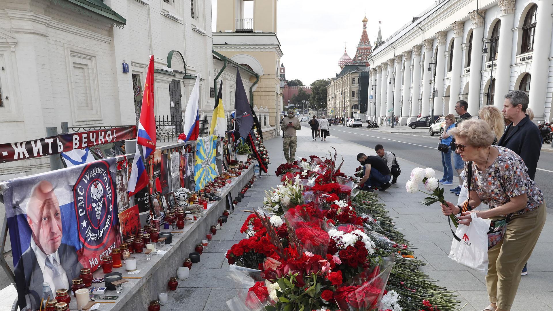 Una mujer deposita flores en un monumento informal en homenaje al jefe del Grupo Wagner, Yevgeny Prigozhin, en Moscú, Rusia