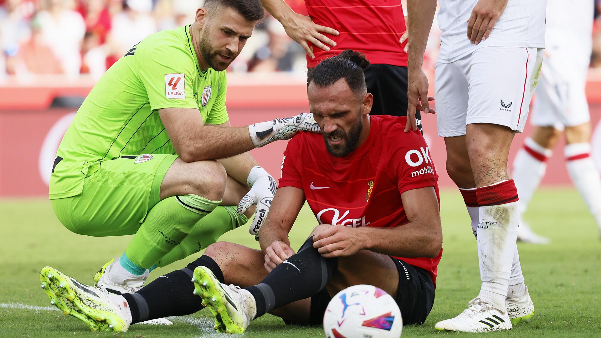 Las asistencias atienden al delantero del Mallorca Vedat Muriqi en presencia del meta Unai Simón