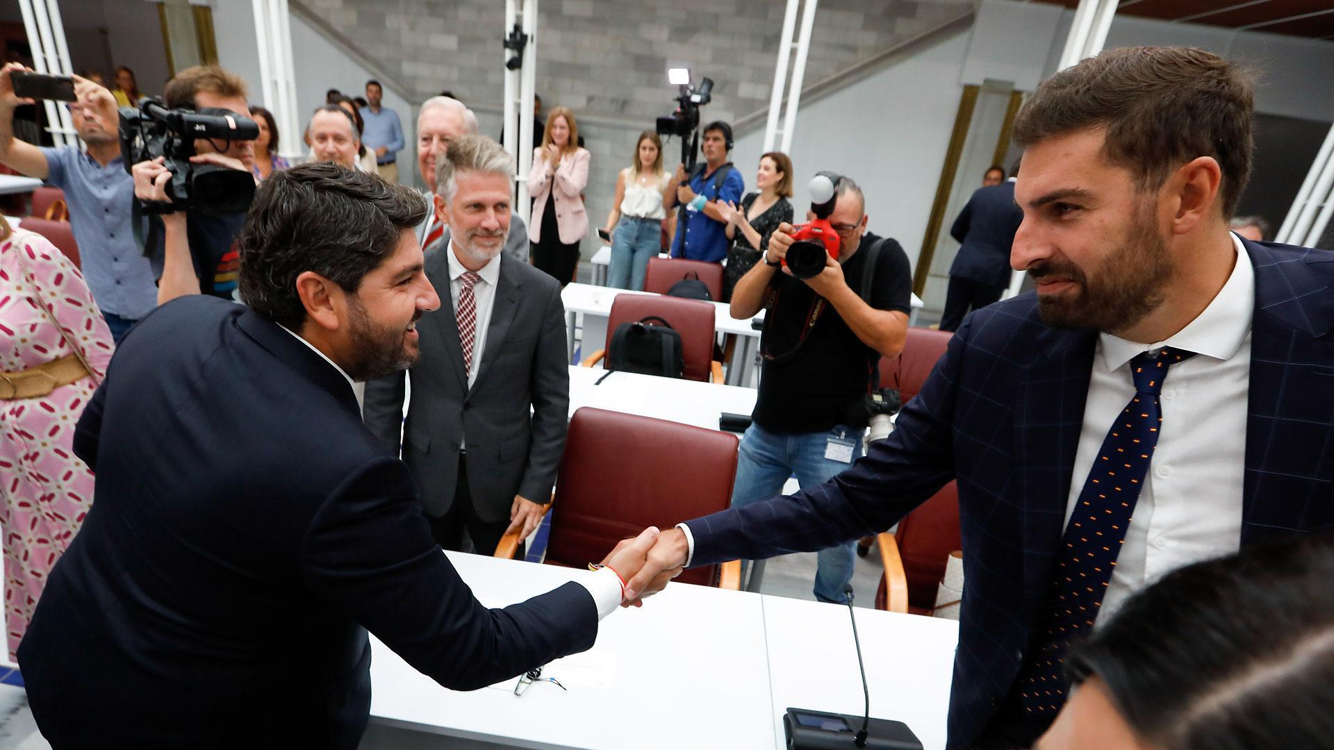 El candidato del Partido Popular para presidir Murcia, Fernando López Miras (i), saluda al presidente de Vox en la Región y diputado en la Asamblea, José Ángel Antelo (d), durante el segundo debate de Investidura