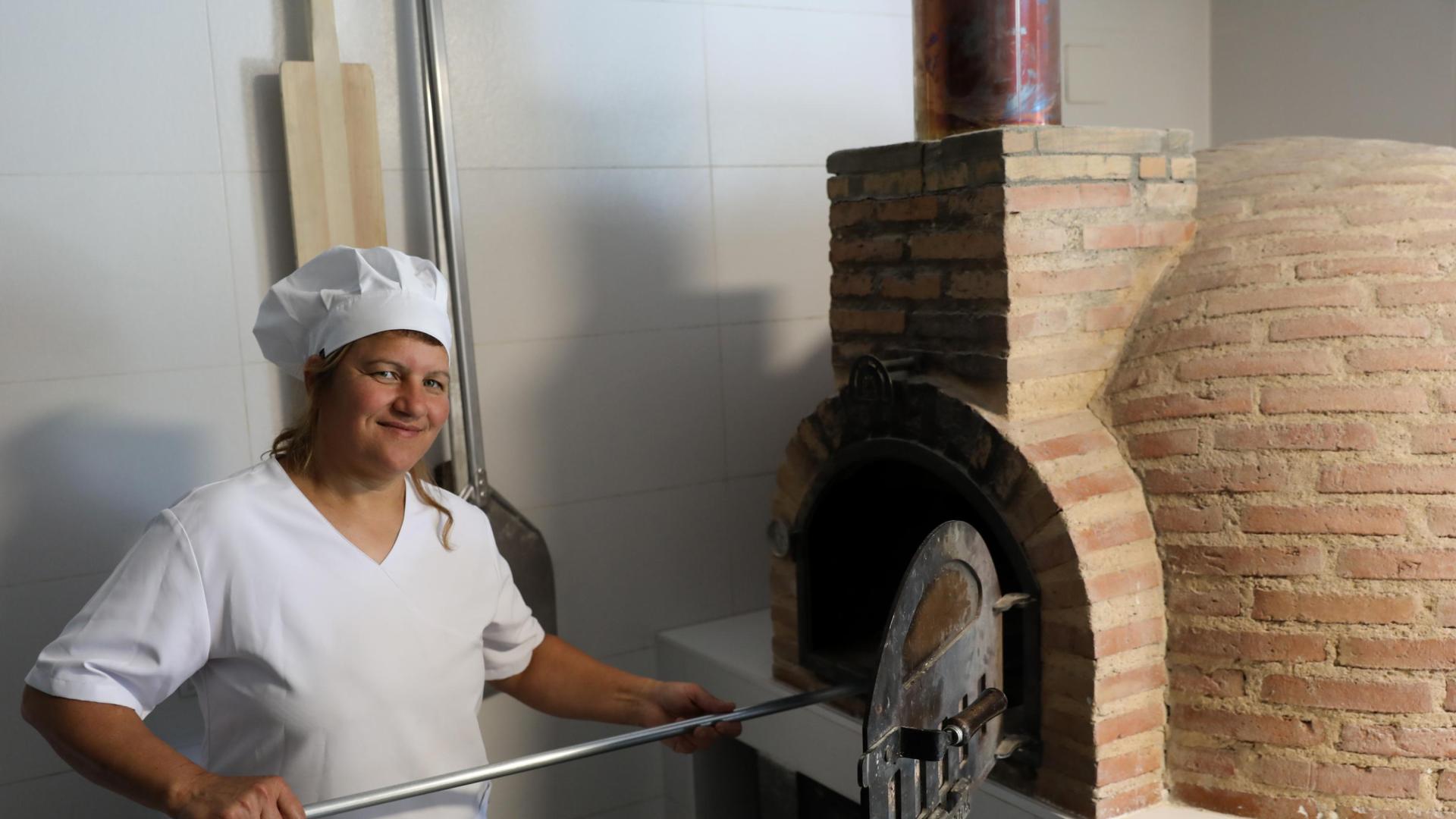 Naasie Murad, horneando pan en el horno de leña de su panadería.