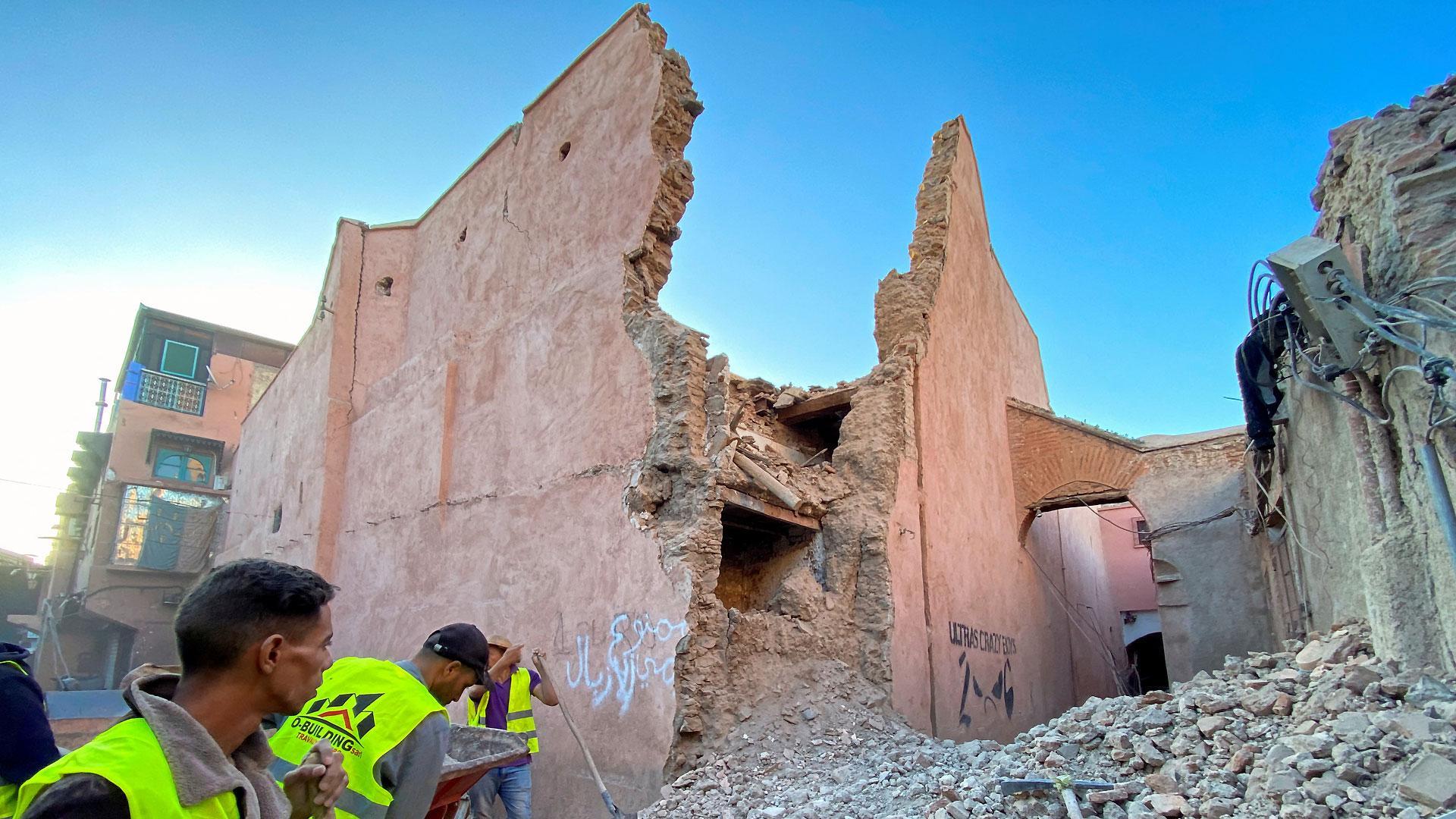 Miembros de los equipos de rescate, junto a un edificio derruido en Marrakech