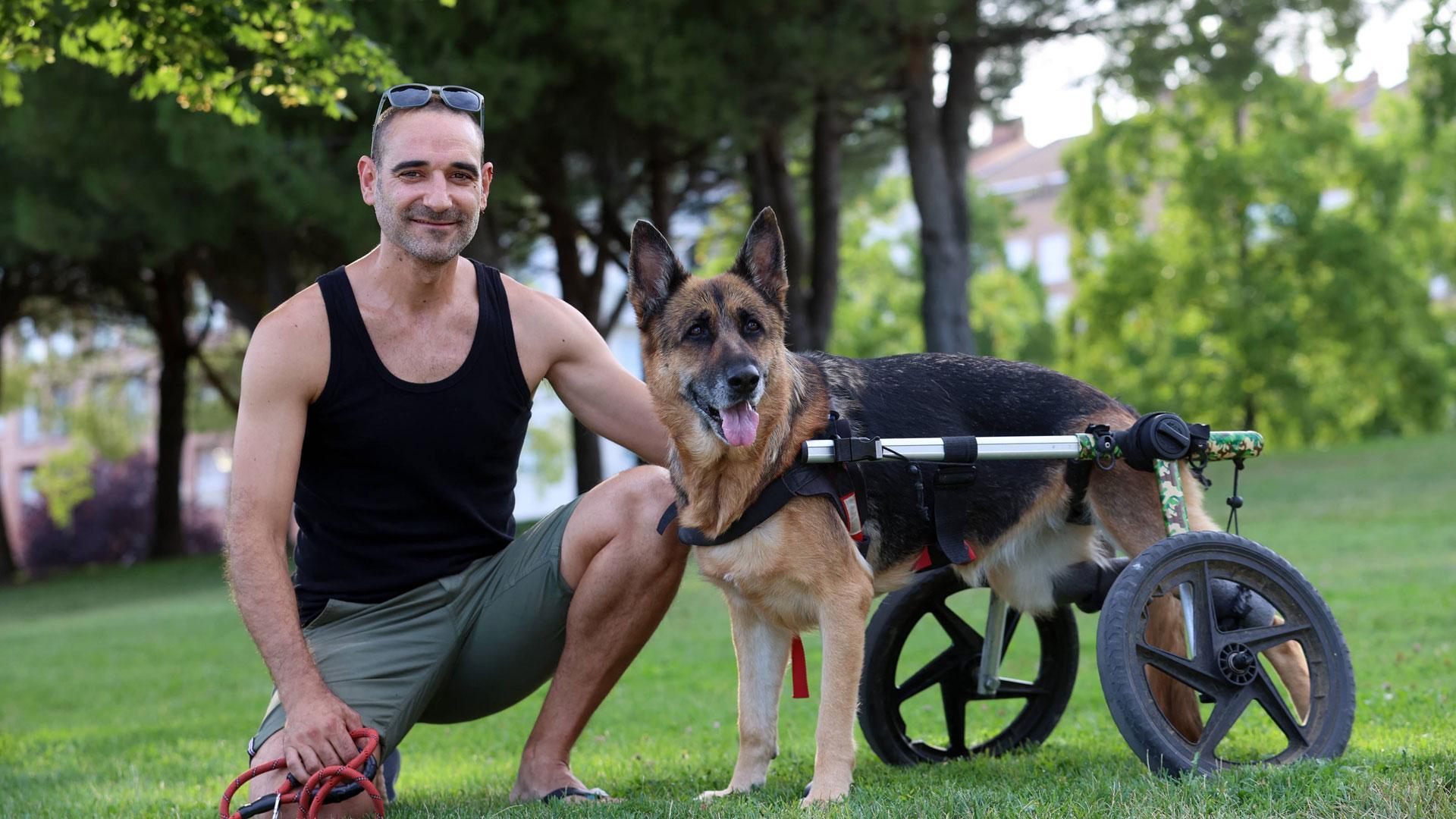 José Mari Martínez posa junto a ‘Nika’, su perra pastor alemán, en un jardín de Barañáin