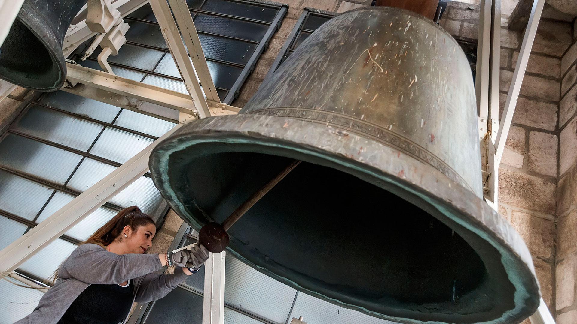 Una campanera toca una campana de la catedral de Burgos