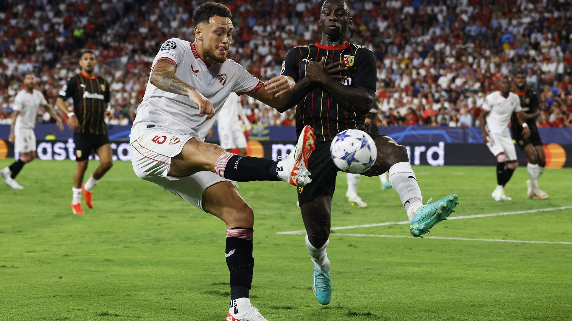 Lucas Ocampos intenta centrar ante el defensa del Lens, Deiver Machado, durante el encuentro