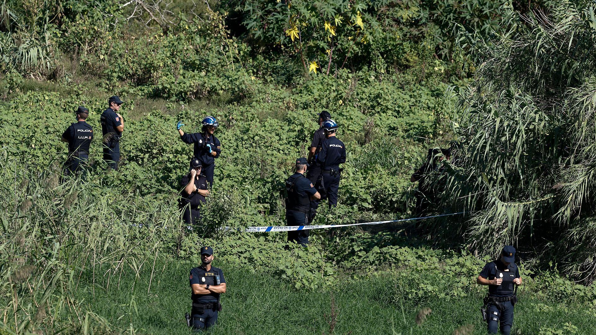 Agentes de la Policía Nacional custodian el lugar donde ha sido hallado el cuerpo sin vida del hombre que fue arrastrado por el agua cuando cruzaba en bicicleta un barranco en Paterna (Valencia)
