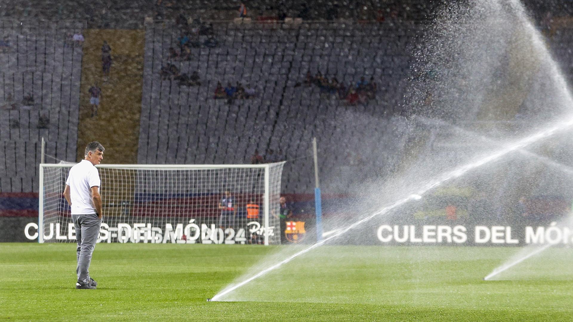 El técnico del Sevilla, José Luis Mendilibar, observa el riego del estadio Olím pico de Lluis Companys antes del choque contra el Barcelona