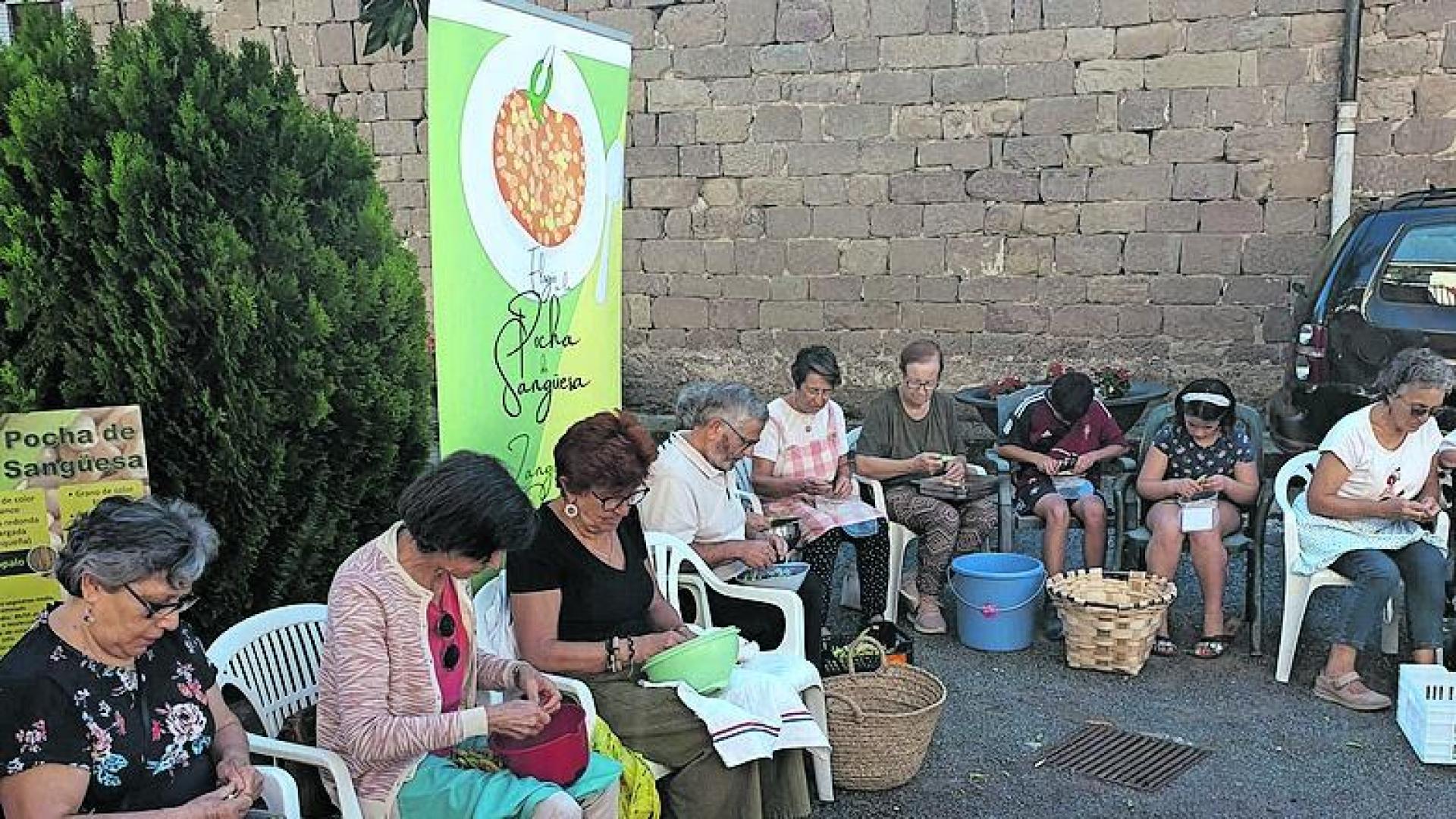 Vecinos y residentes desgranan pochas en la residencia de Sangüesa.