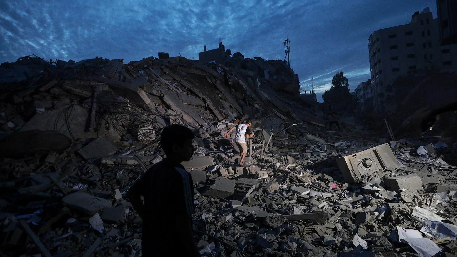 Niños palestinos sobre escombros en una zona de Gaza
