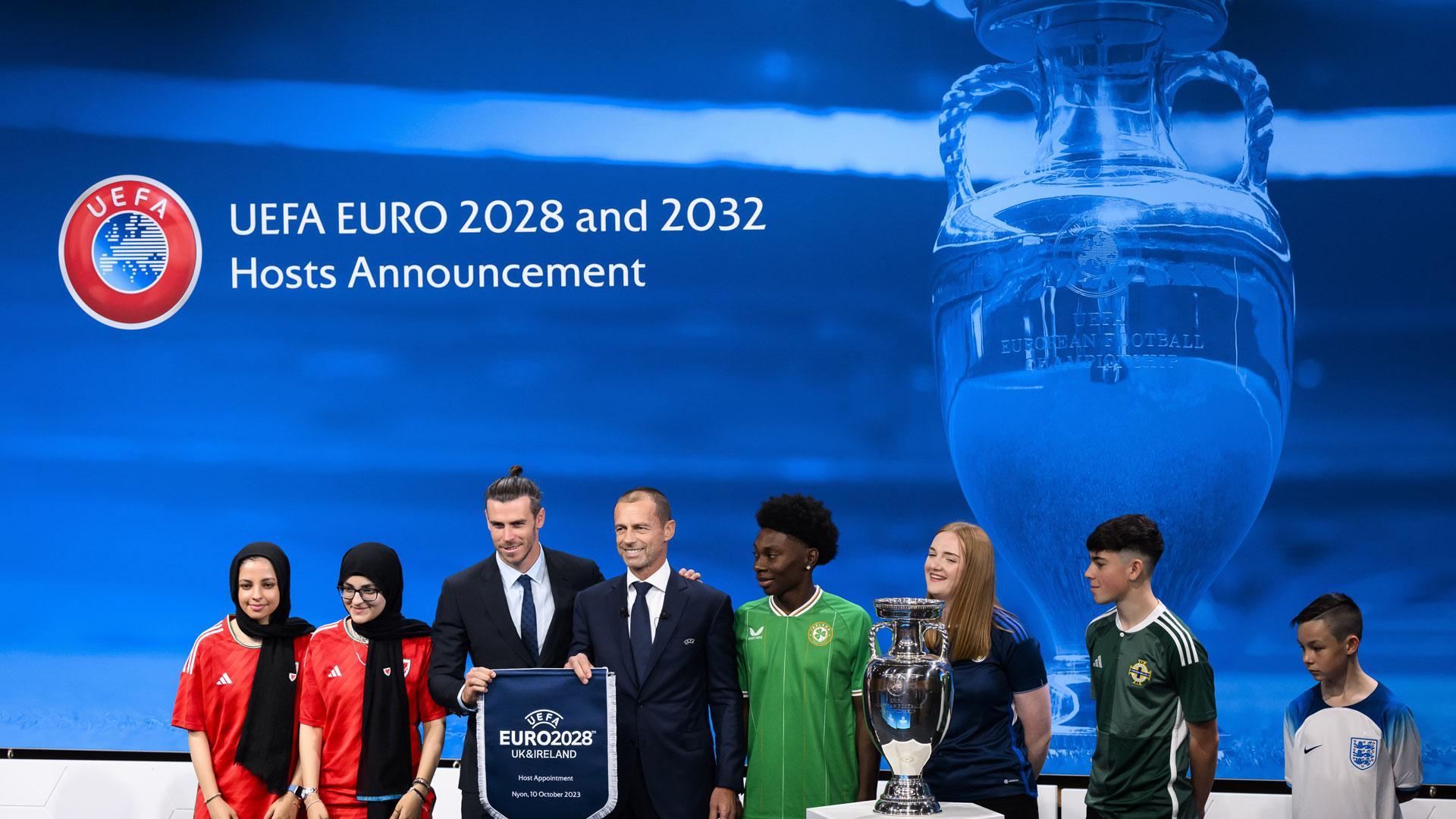 El presidente de la UEFA, Aleksander Ceferin, muestra el nombre del Reino Unido e Irlanda elegidos para albergar la Eurocopa 2028 junto a Gareth Bale, futbolista galés y embajador durante la ceremonia de anuncio de los países organizadores