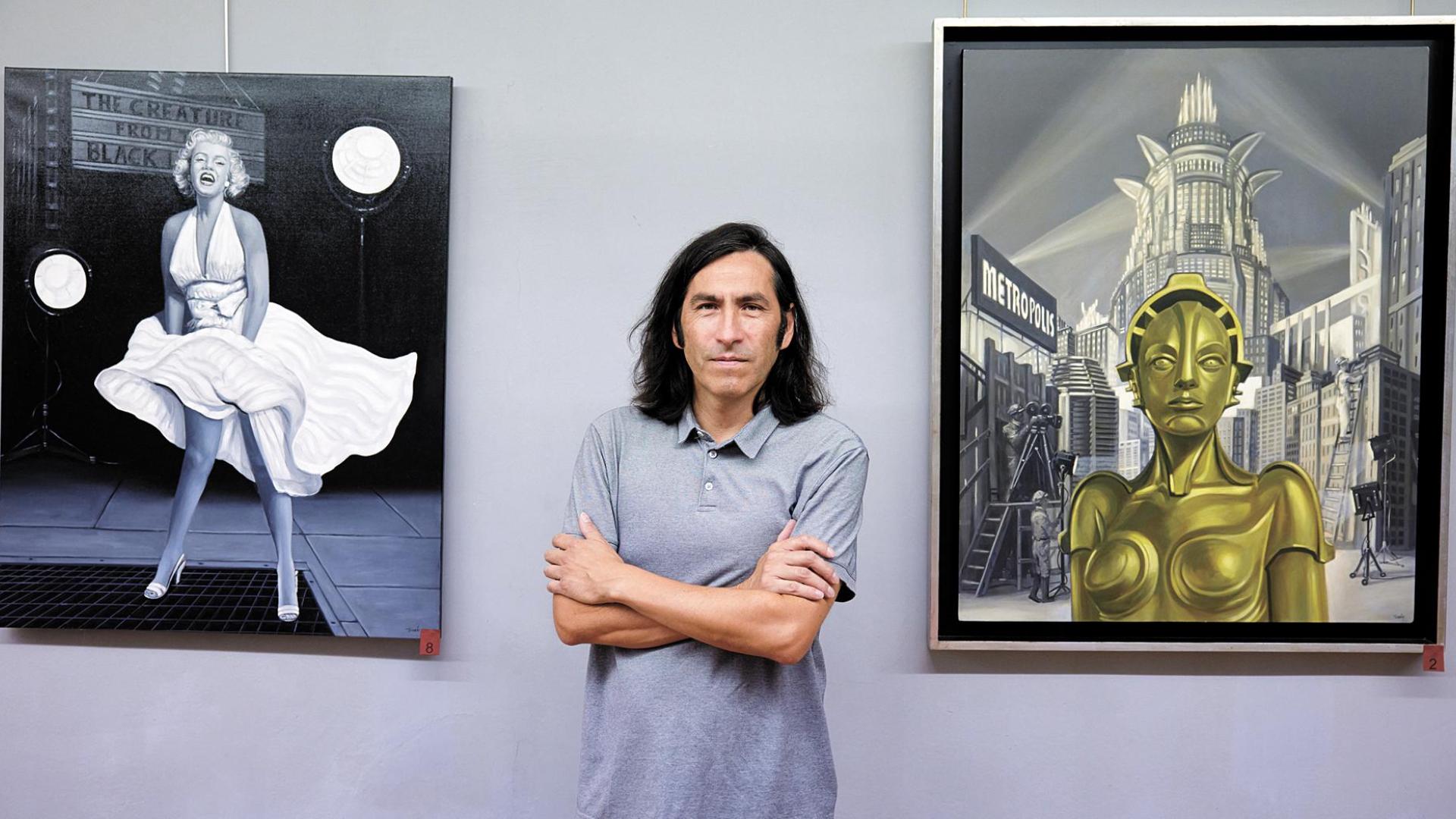 Manuel Terán posa en la galería junto a las obras La tentación vive arriba (izda) y Metrópolis