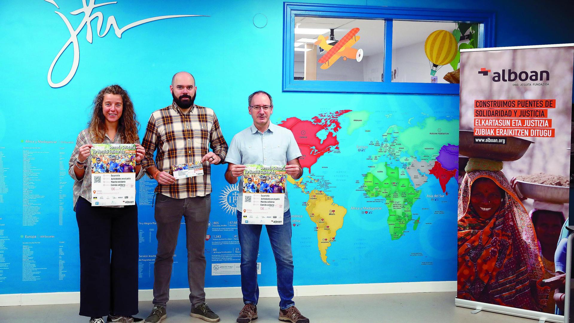 De izda a dcha: Annalisa Lenti (Alboan), Ignacio Aranzadi (Centro Loyola) y Carlos Moraza (Colegio San Ignacio, Jesuitas, de Pamplona), ayer junto al cartel sobre la jornada solidaria. 	José Carlos Cordovilla