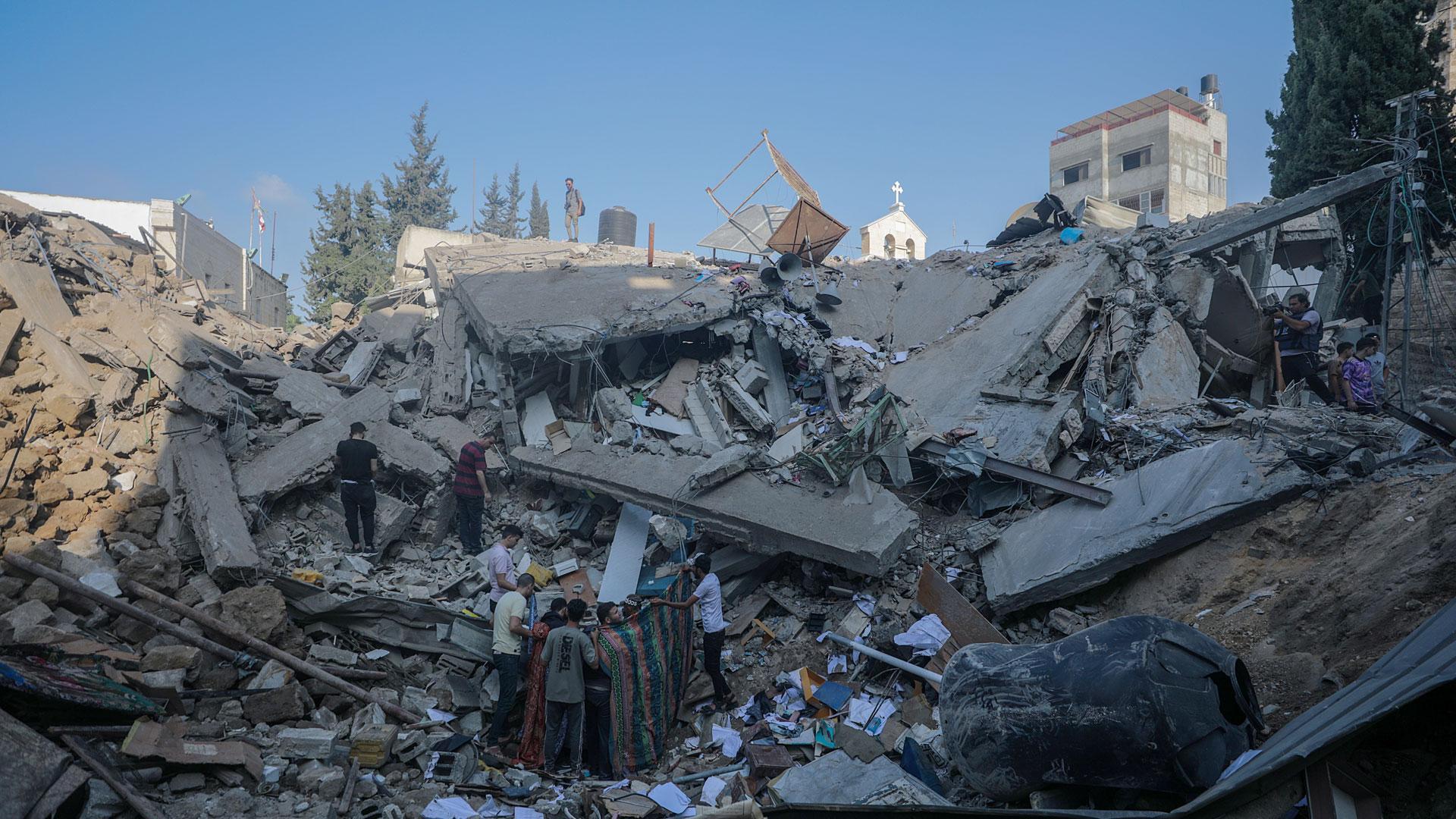 Un grupo de palestinos buscan supervivientes y cadáveres entre los escombros de la iglesia ortodoxa griega de San Porfirio tras un ataque aéreo nocturno de Israel en Gaza