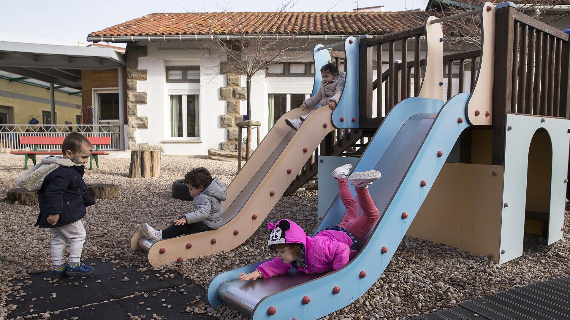 Unos niños juegan en los columpios del patio de recreo de una escuela infantil de Pamplona