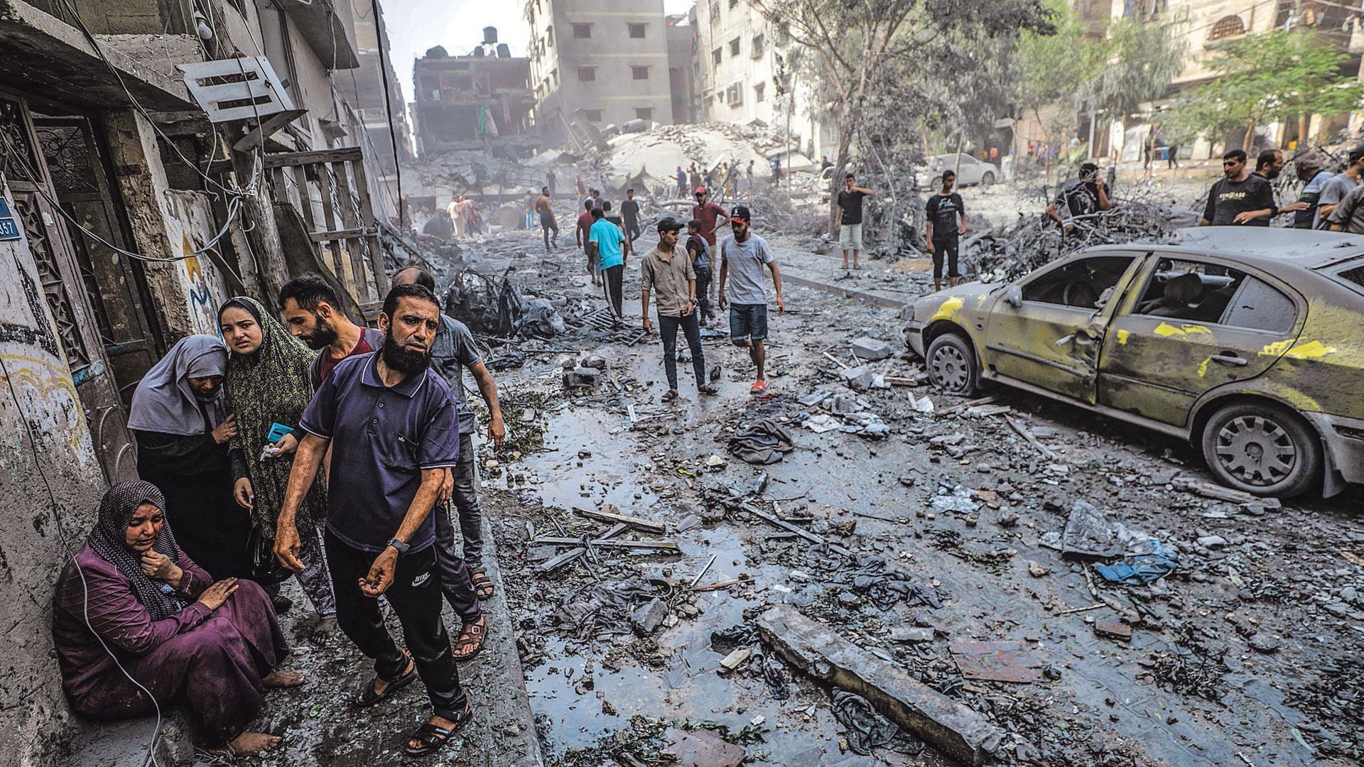 Una familia palestina se lamenta en una calle de la Ciudad de Gaza completamente destruida por los bombardeos de la aviación israelí