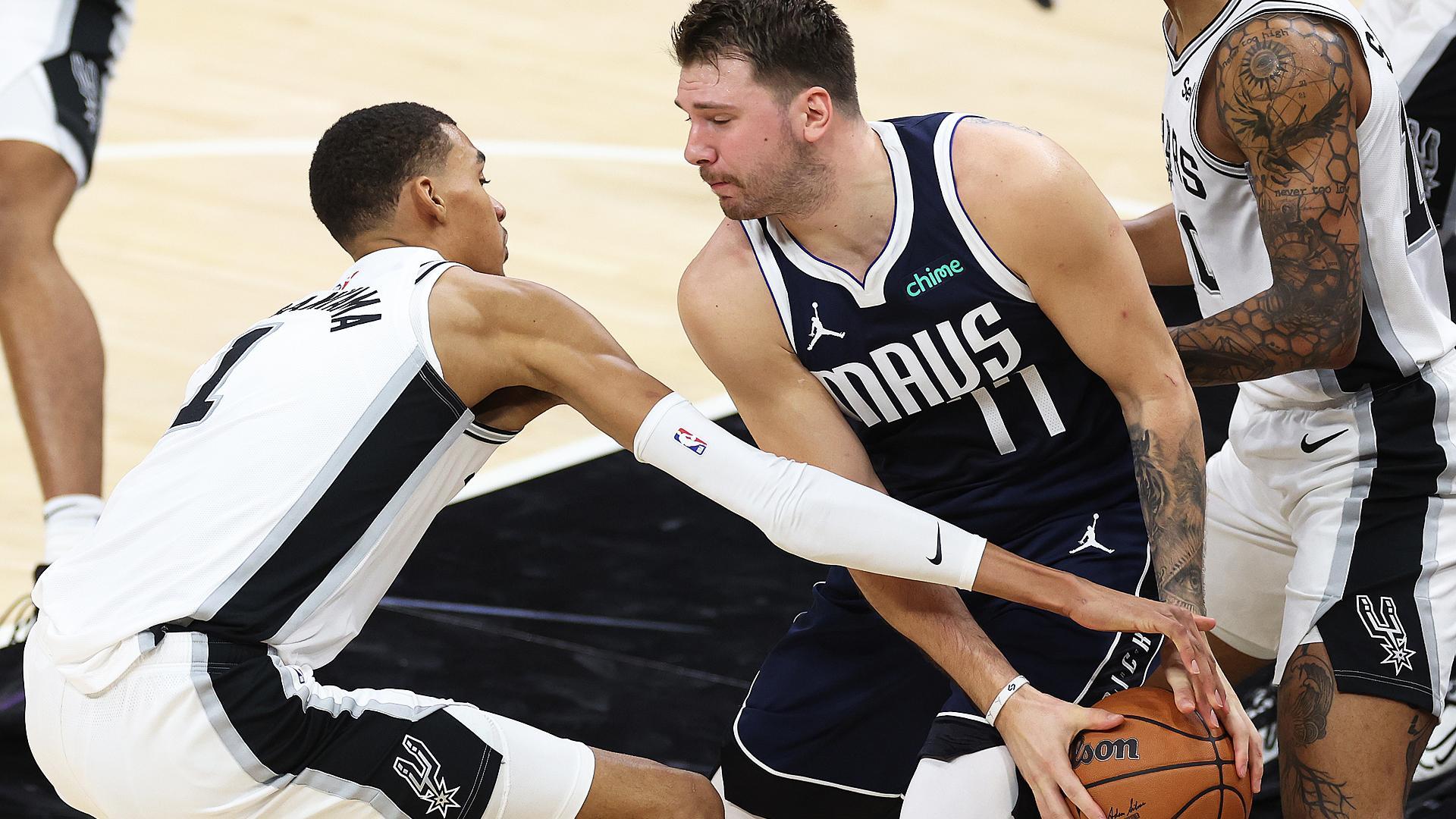 Victor Wembanyama (izda.) y Luka Doncic(dcha.) pelean por el balón durante el encuentro